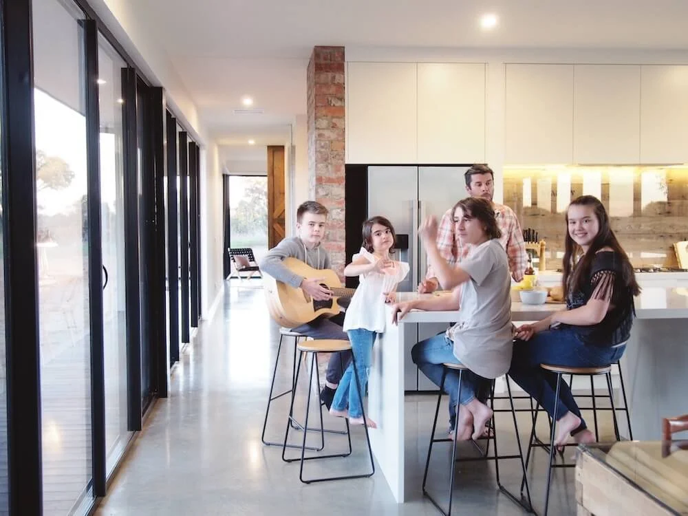 Boots and the kids sitting in the light-filled kitchen at Booken House