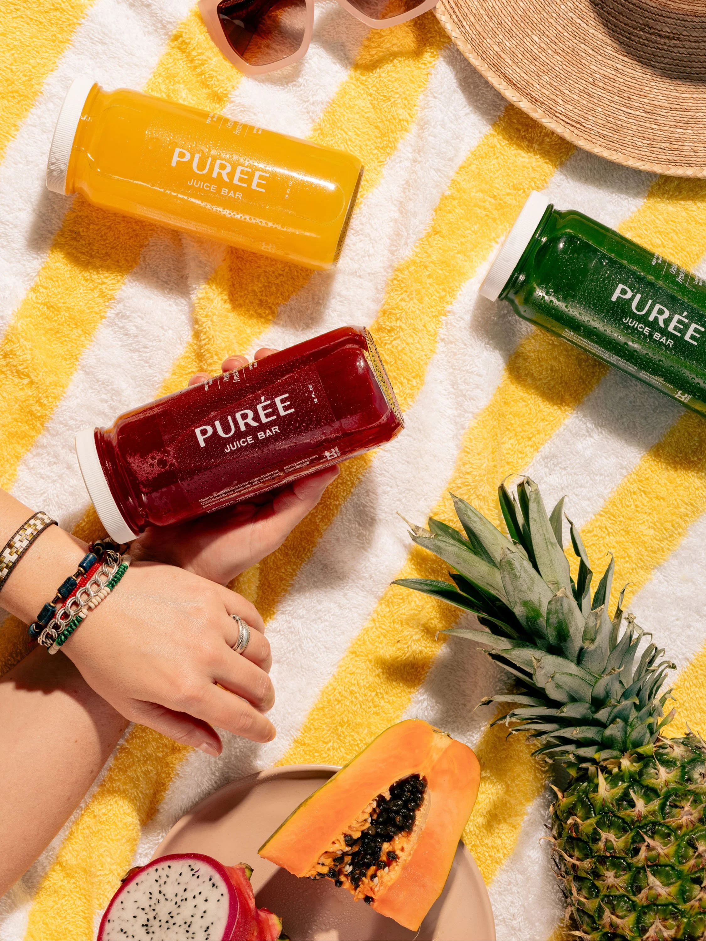 53-puree-juice-bar-juice-bottles-beach-towel-lifestyle-photography.jpg