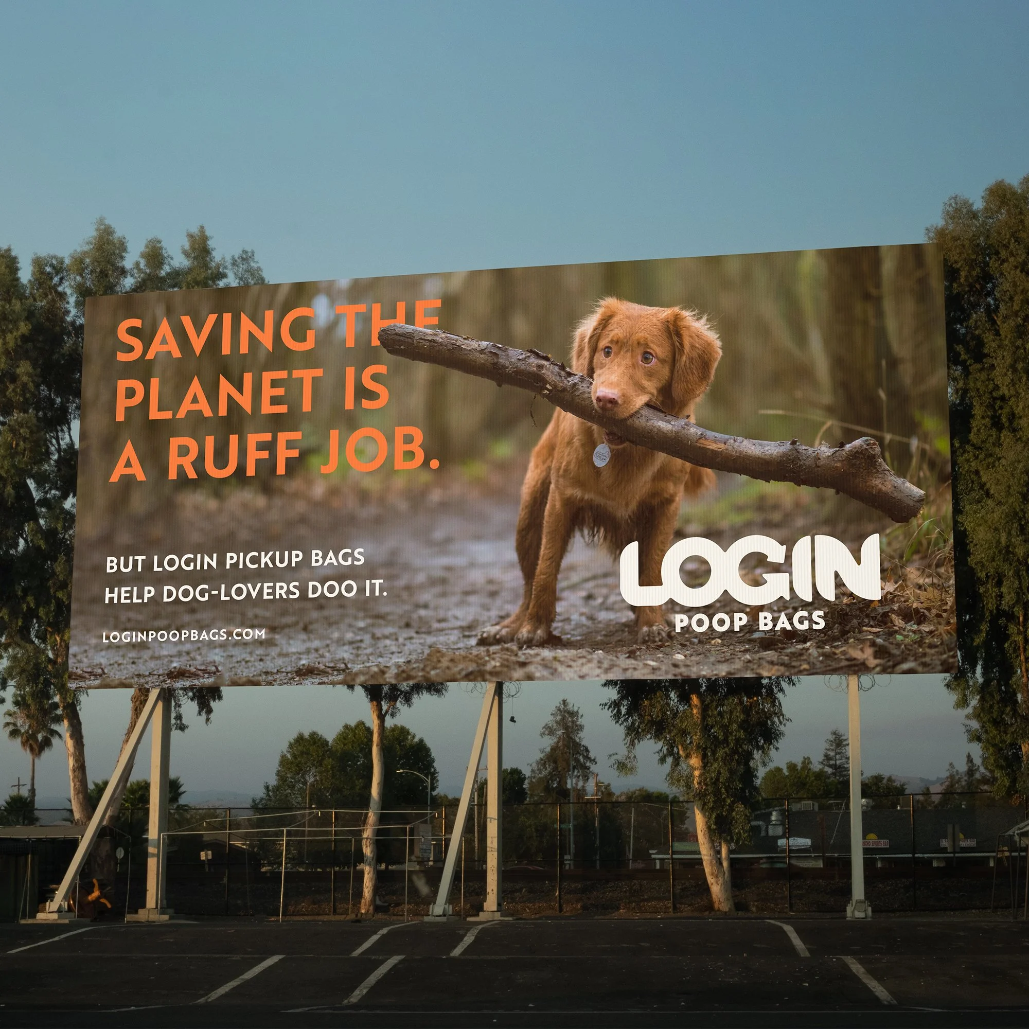 Billboard ad with a photo of a cute brown puppy holding a large stick in its mouth, promoting dog poop bags. The text reads: "Saving the planet is a ruff job. But login pickup bags help dog-lovers doo it." The website loginpoopbags.com is included.