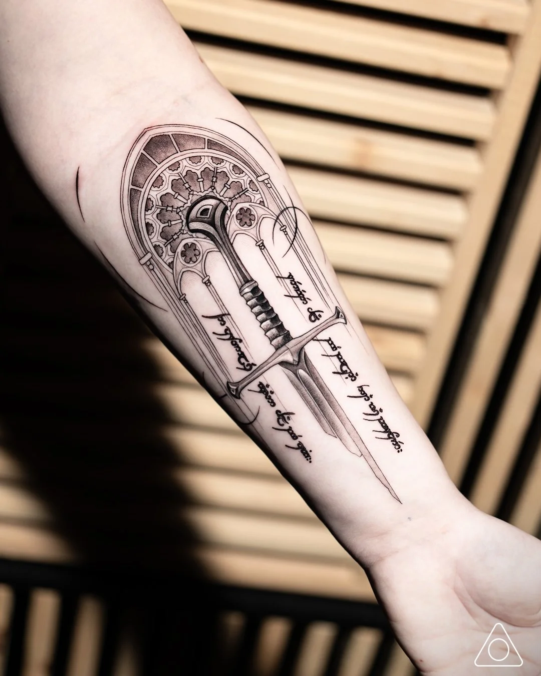 Fine-line Narsil sword tattoo with Gothic window background, inner forearm tattoo art by tattoo artist in Los Angeles California