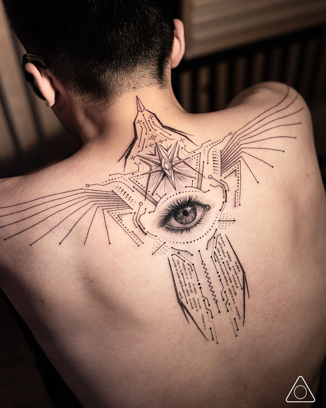 Prime Vessel fine line geometric phoenix tattoo with central eye and star compass on upper back, aligned to spine, completed in Los Angeles, CA