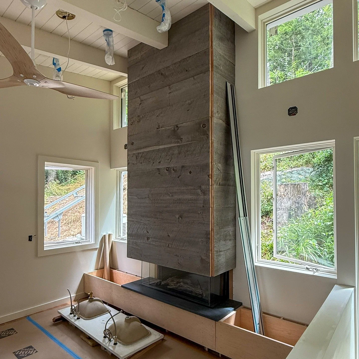 Interiors are moving along nicely at our Putnam Valley Lake House. 

The fireplace adds a warm element to the uphill side of the house. The windows to either side of the fireplace and the butterfly roof open up what is essentially a green wall as the