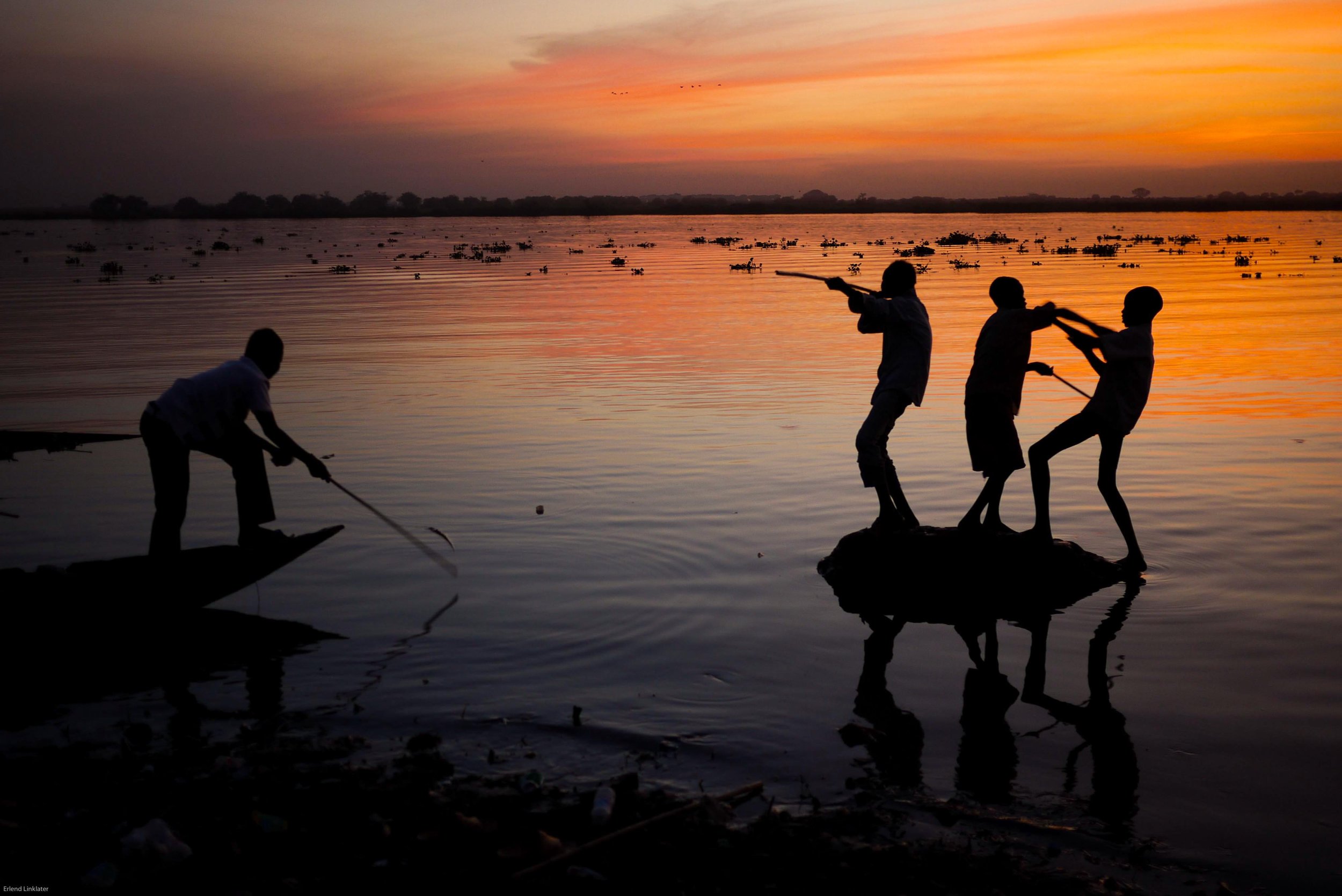 Boys distracted from fishing fight and play war games with their fishing rods, Malakal, South Sudan, 2011. With the conflict having lasted for over 30 years, many have only ever known the violence and instability that it brought.