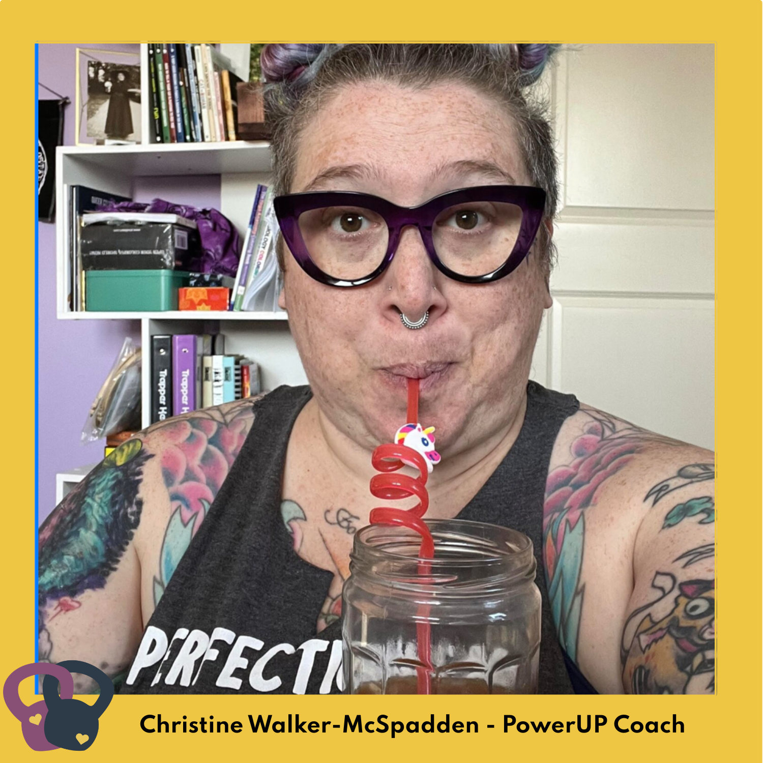 Coach Christine is a plus size white person with lots of tattoos. They are sipping from a glass with a curly red straw, with a bemused expression.