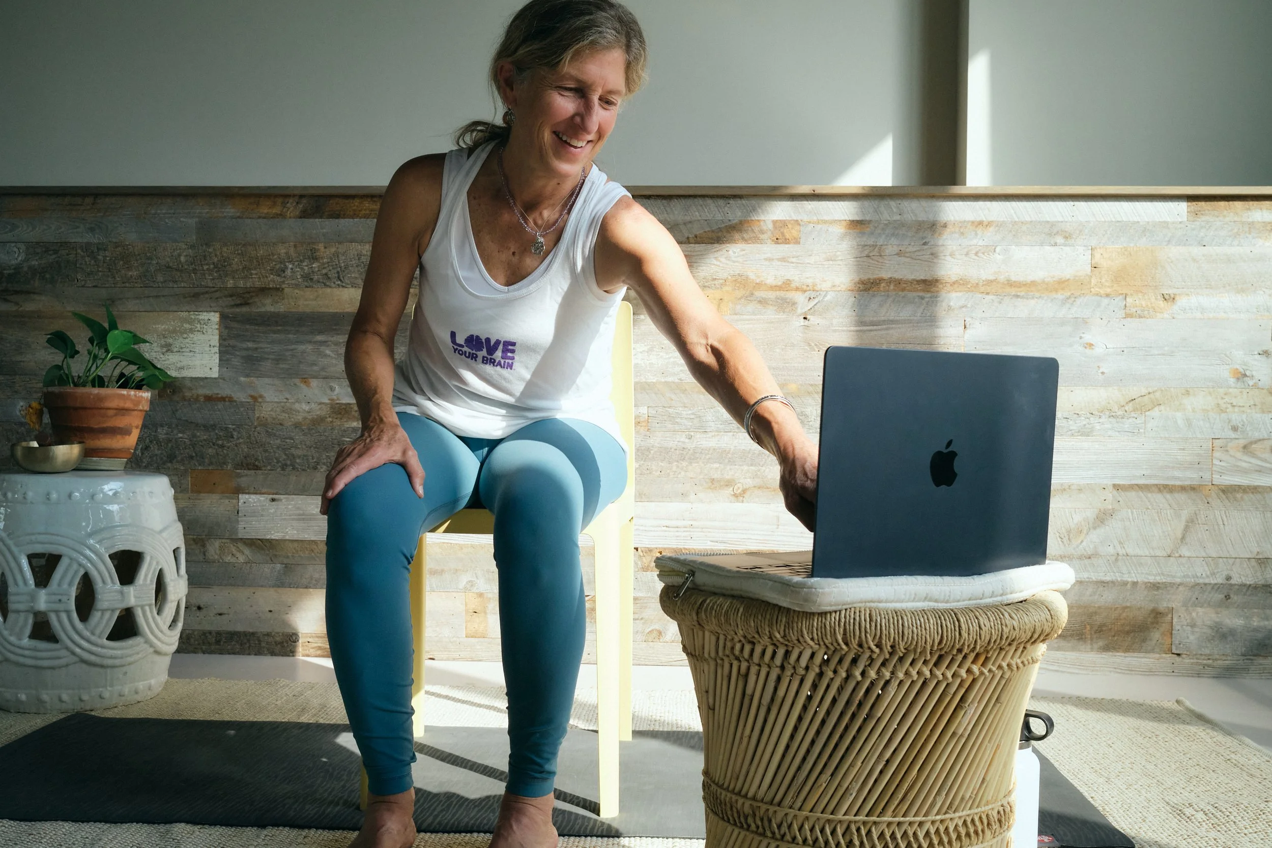 A person meditating next to a computer