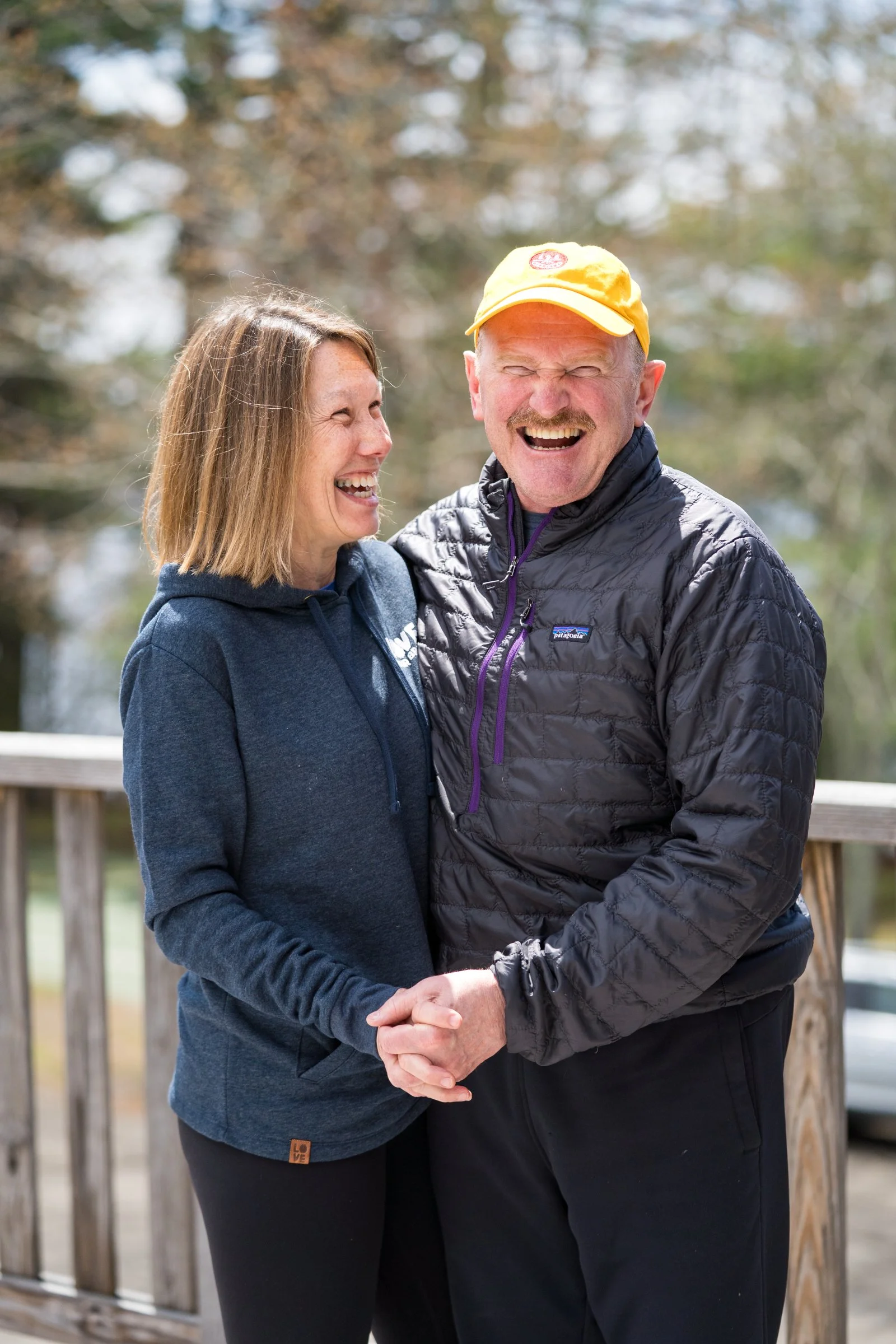 Caregiver couple laugh outside at a brain injury retreat