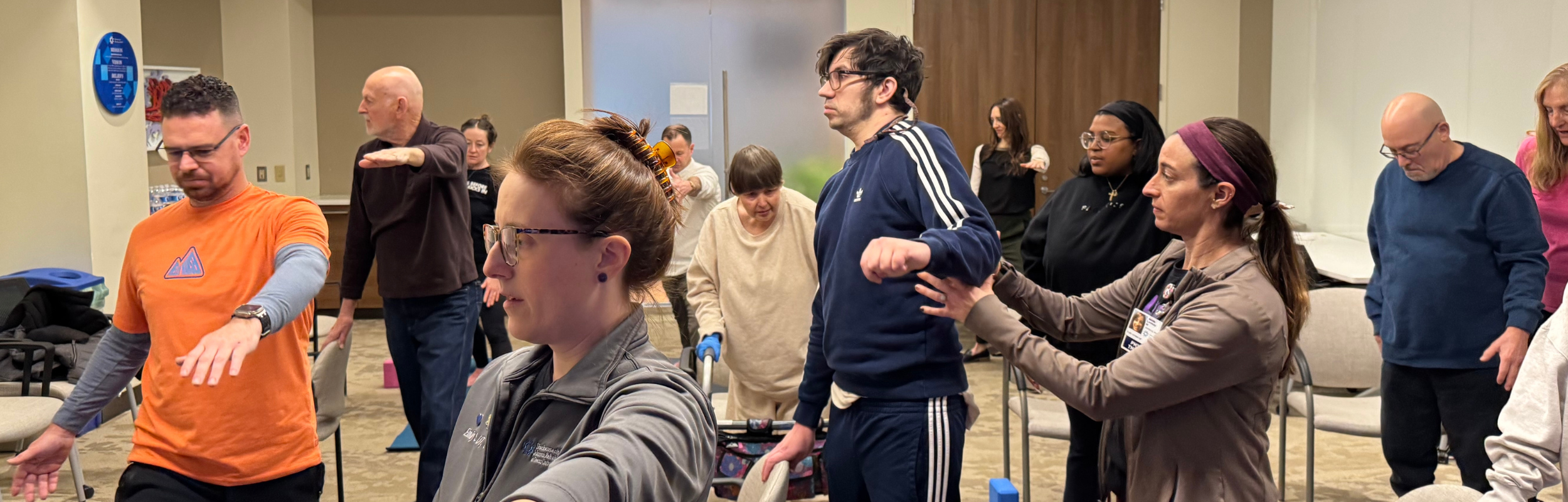 man being helped by clinician in outpatient group yoga class