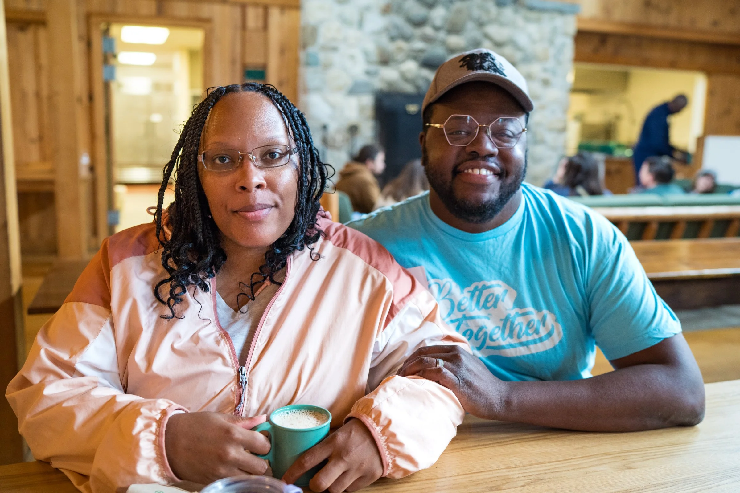 Two young BIPOC individuals sit side by side at brain injury retreat