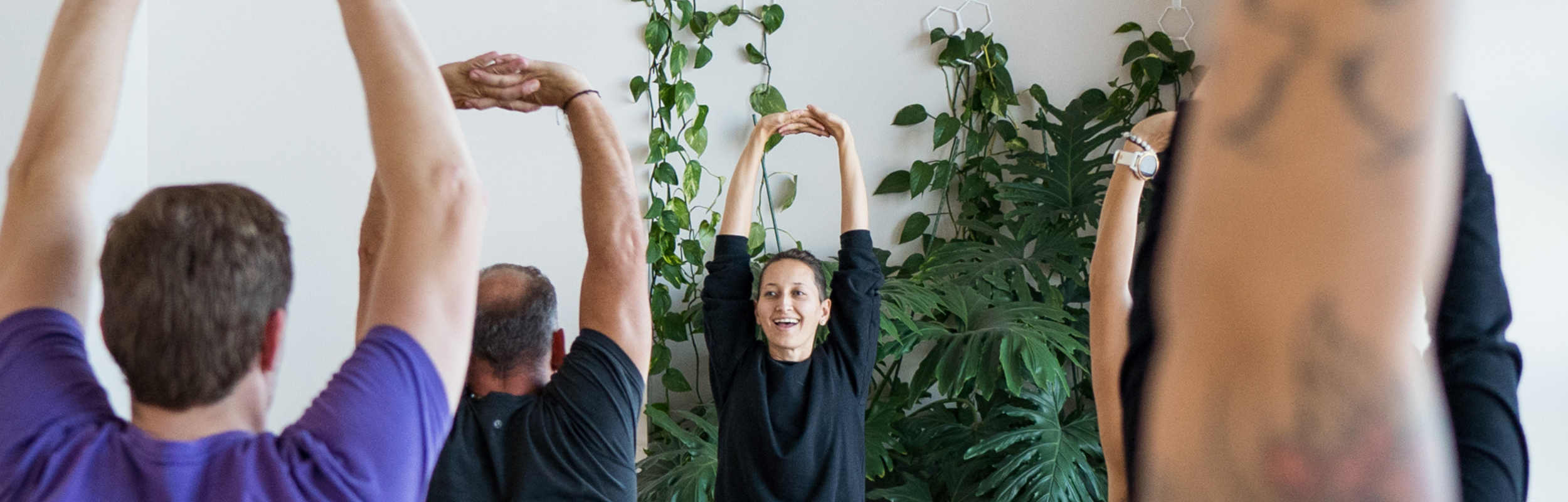 yoga class participants with arms raised