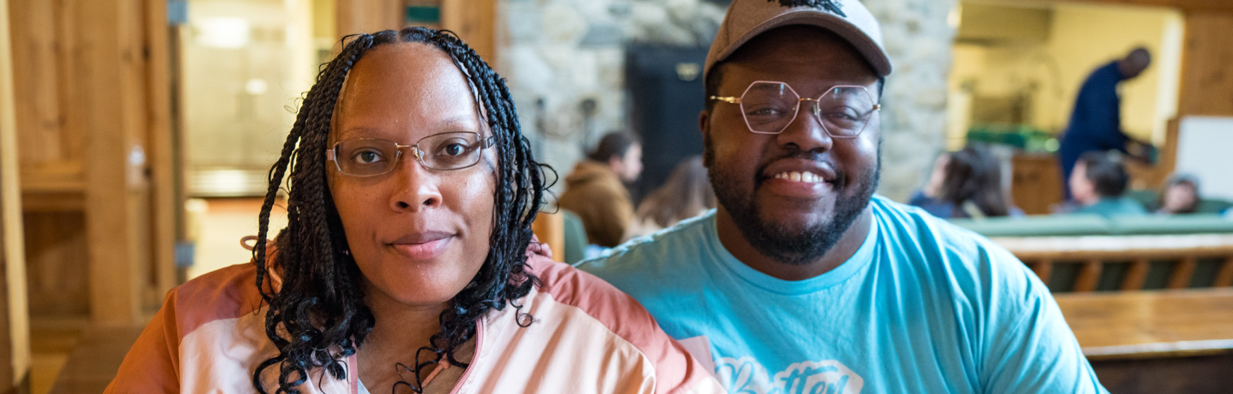 husband and wife caregiver team looking at camera