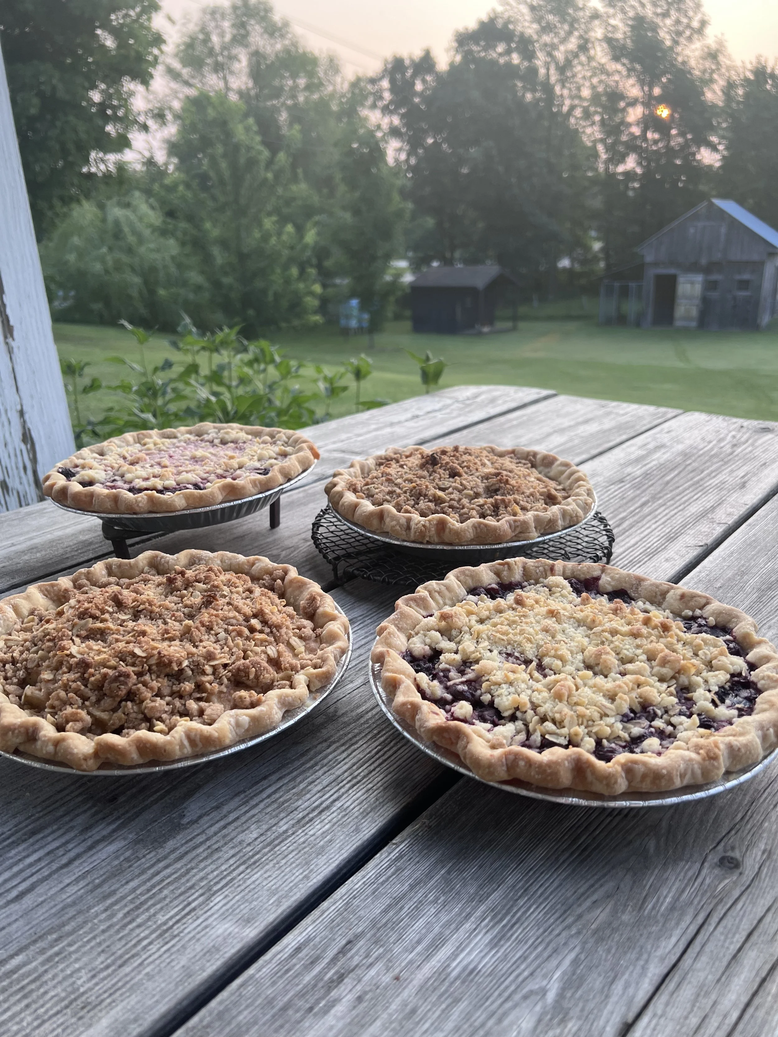 4 pies cooling on a wooden table