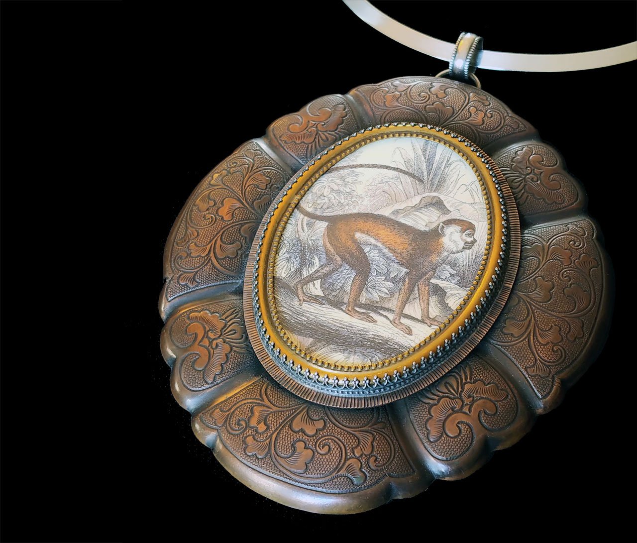   Gentle Friend Pendant  by Roberta &amp; David Williamson of vintage monkey print, sterling silver, watchmakers crystal, bronze and copper; soldered, bezel set, roller printed, 2016. 