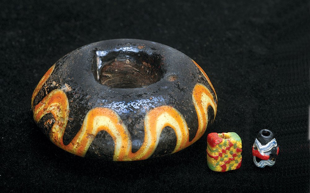  LARGEST AND SMALLEST ISLAMIC GLASS BEADS: HEBRON BICONE DISK BEAD, 3.7 centimeter diameter, and SMALL TRAILED BARREL BEAD, 0.8 centimeters high, both from Turkey, and SQUARE TABULAR CHEQUER BEAD, 0.7 centimeters high, from Mauritania.  Courtesy of T