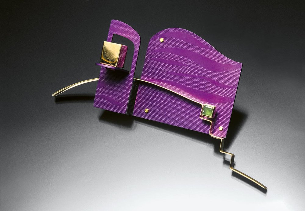  COMPOSITION WITH CUBE (Brooch) of anodized aluminum, eighteen karat gold, emerald; fabricated and silent metal forming, 6.4 × 14.0 × 3.2 centimeters, 1993.  Private collection. Photograph by Peter Krumhardt.  