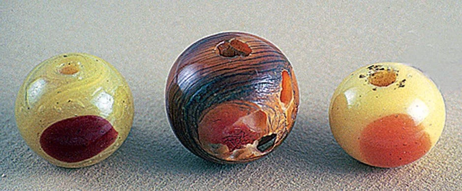  REAL AND GLASS SIMULATIONS OF HORNBILL BEADS USED AS OJIME: precious materials were often copied and used as ojime—actual hornbill bead has been damaged by insects eating into the casque of the keratin protein used for making this ojime. The image b