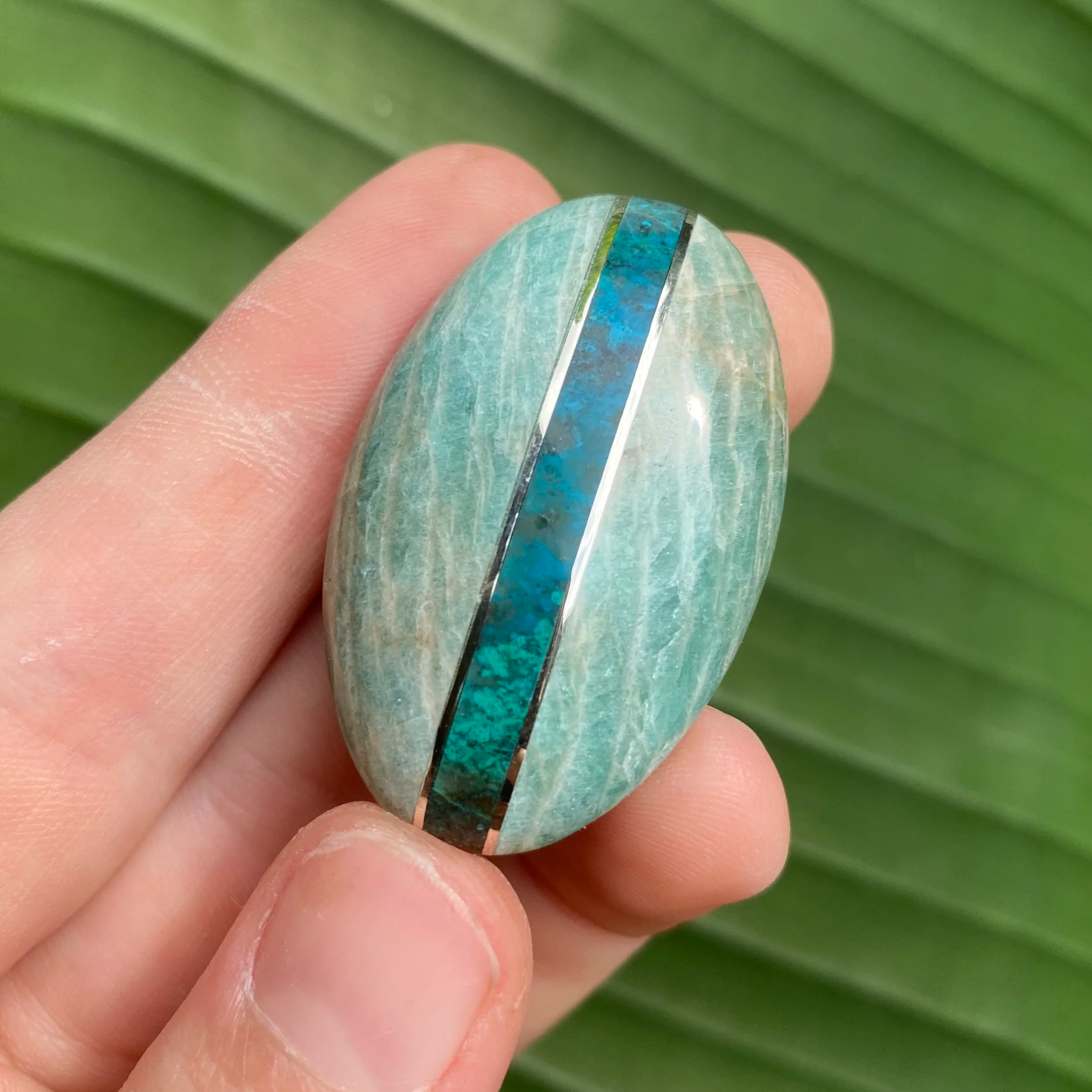 Custom stone intarsia made with amazonite, chrysocolla, and sterling silver banding in an oval shape. This shows how intarsias are a stand-alone mosaic.