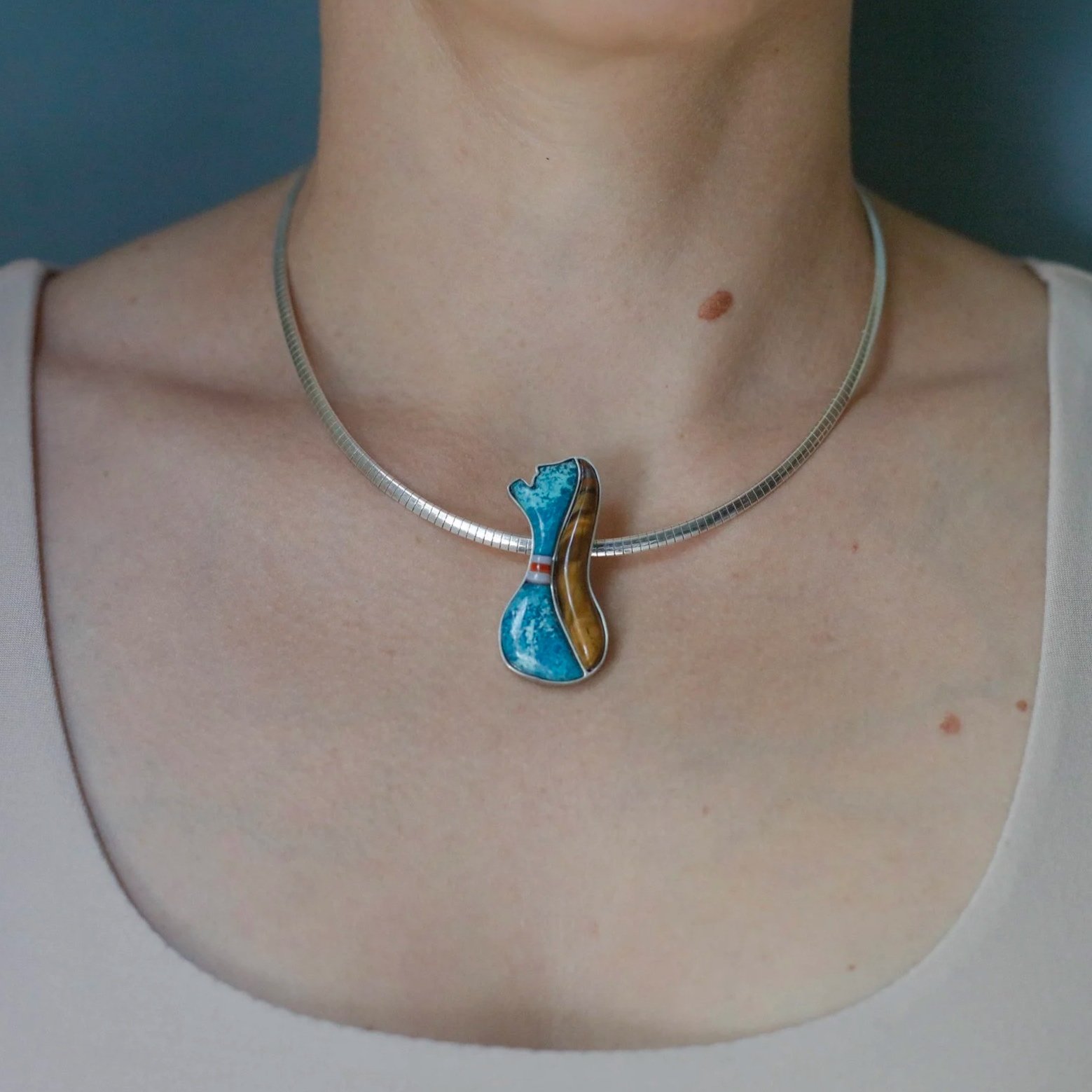 Female figure cobblestone inlay with hand-cut shattuckite, spiny oyster shell, tigers eye, and white agatized coral