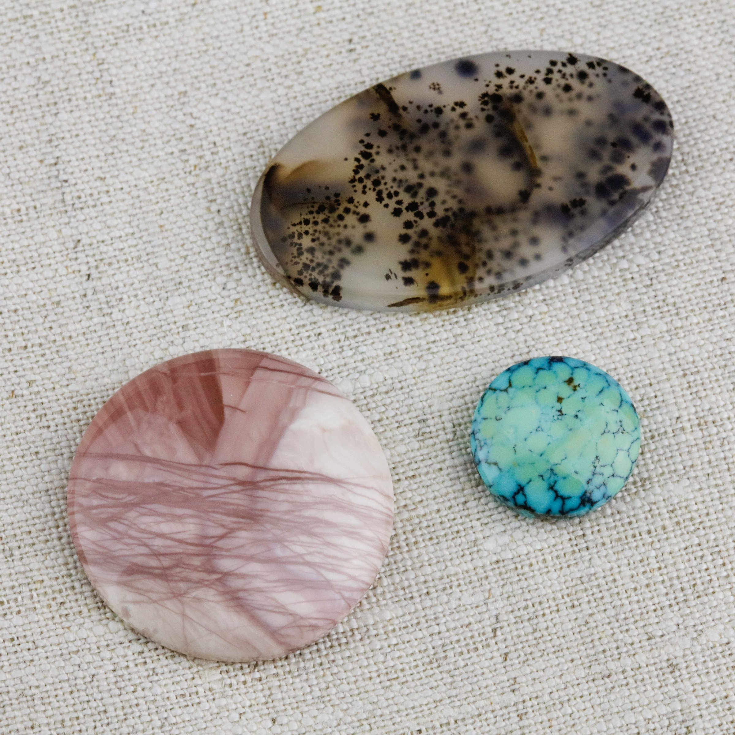 Examples of what a cabochon is with an imperial jasper cabochon, a Montana agate cabochon, and a Hubei turquoise cabochon