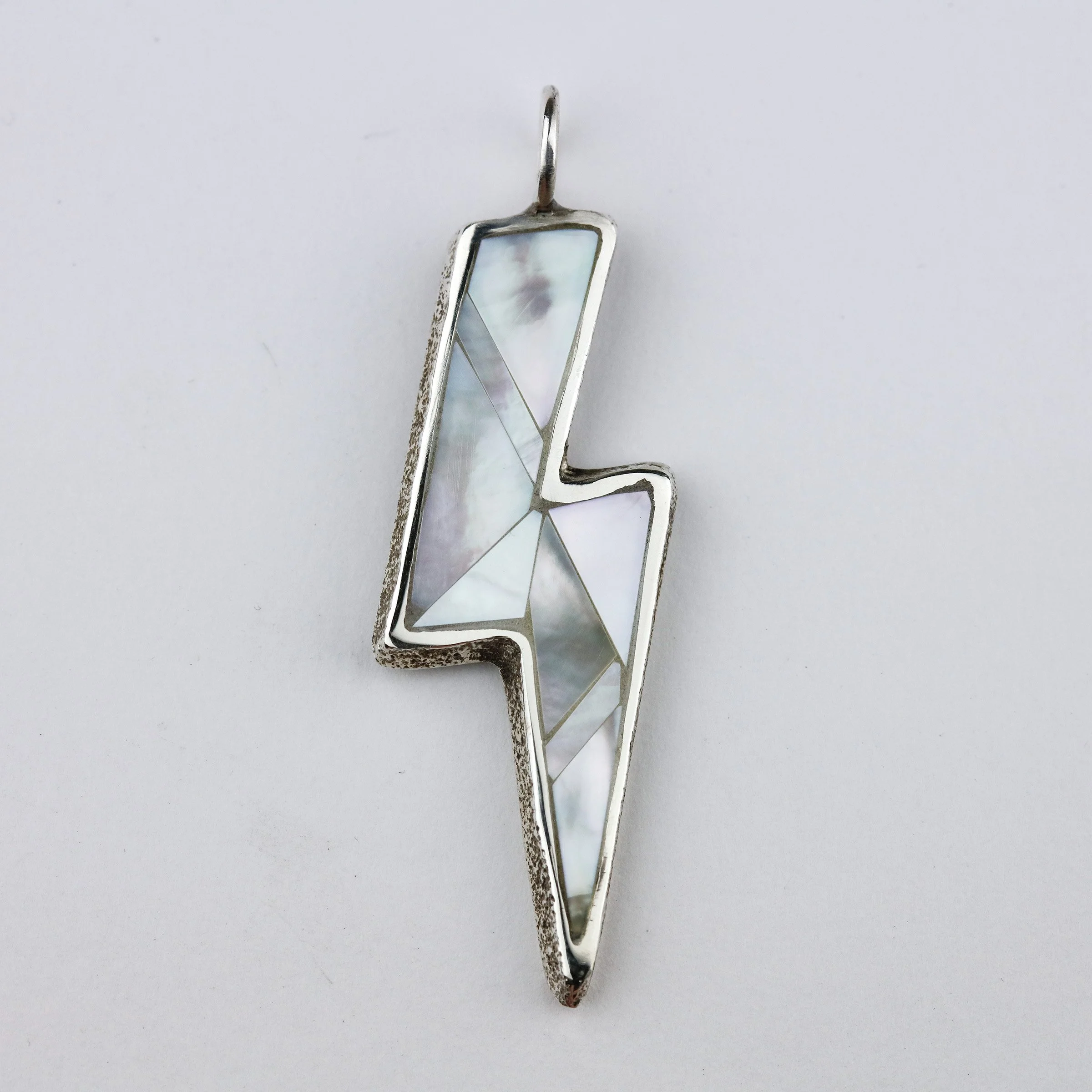 I came up with a few different contemporary inlay design options, and they chose this one that really accentuated the power of the lightning bolt in all mother-of-pearl.