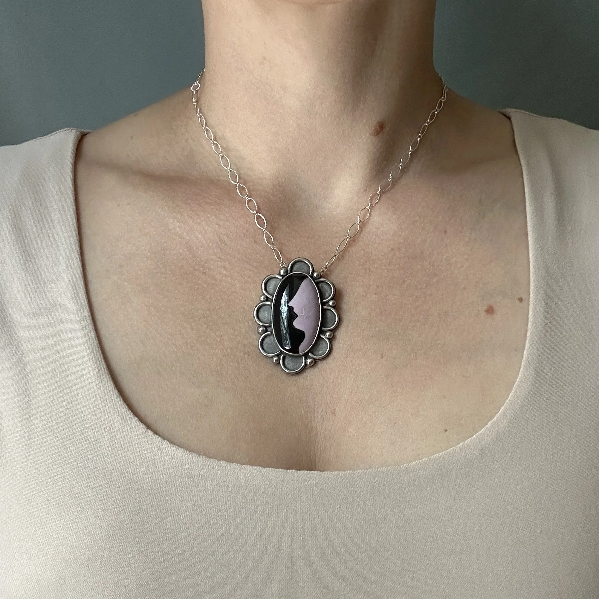 Phosphosiderite and obsidian cameo necklace in sterling silver, modeled on the jewelry artist for scale