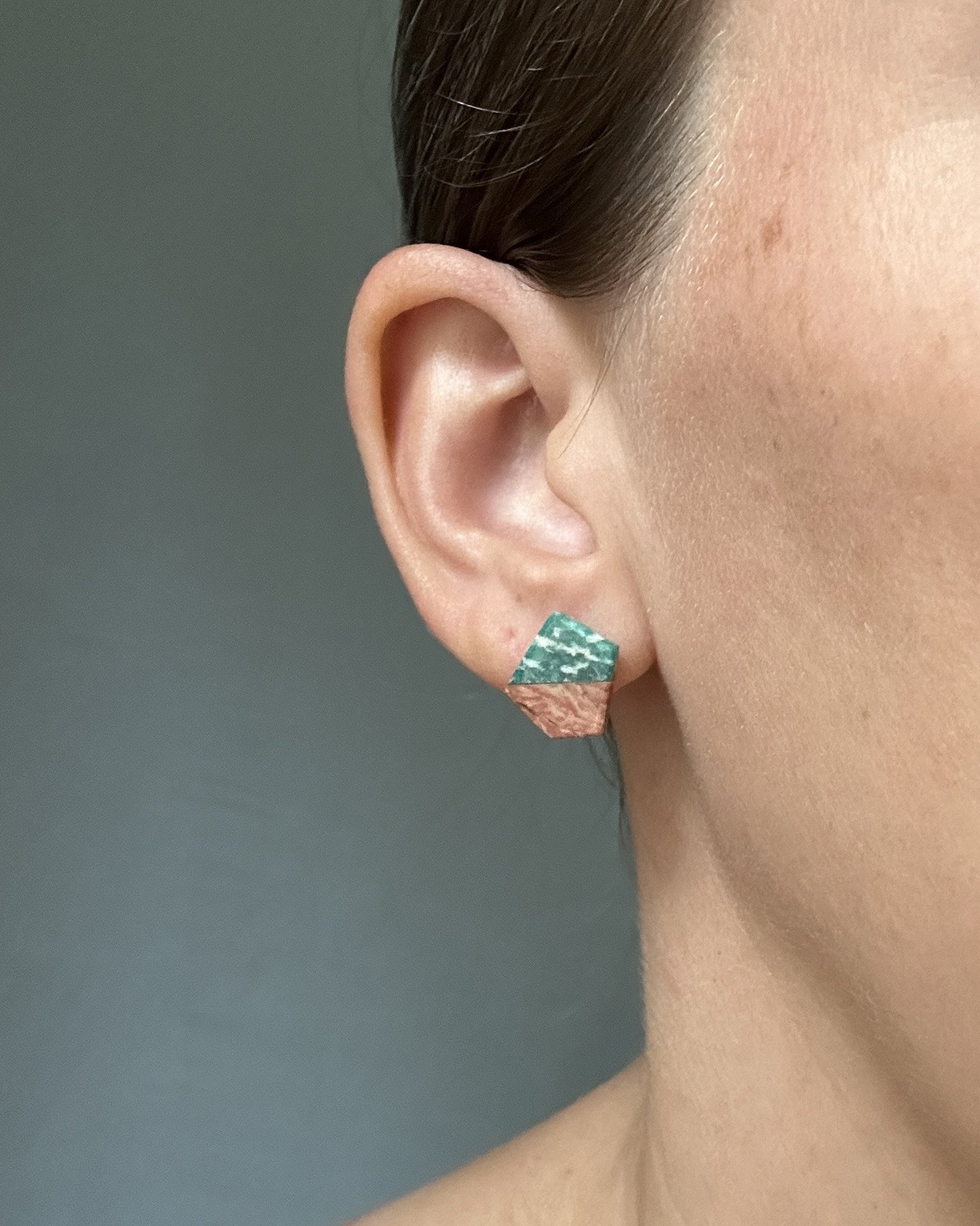 Stone Intarsia Stud Earrings with Perthite and Howardite; picture of earring modeled on the lapidary artist Caitlin Albritton for scale