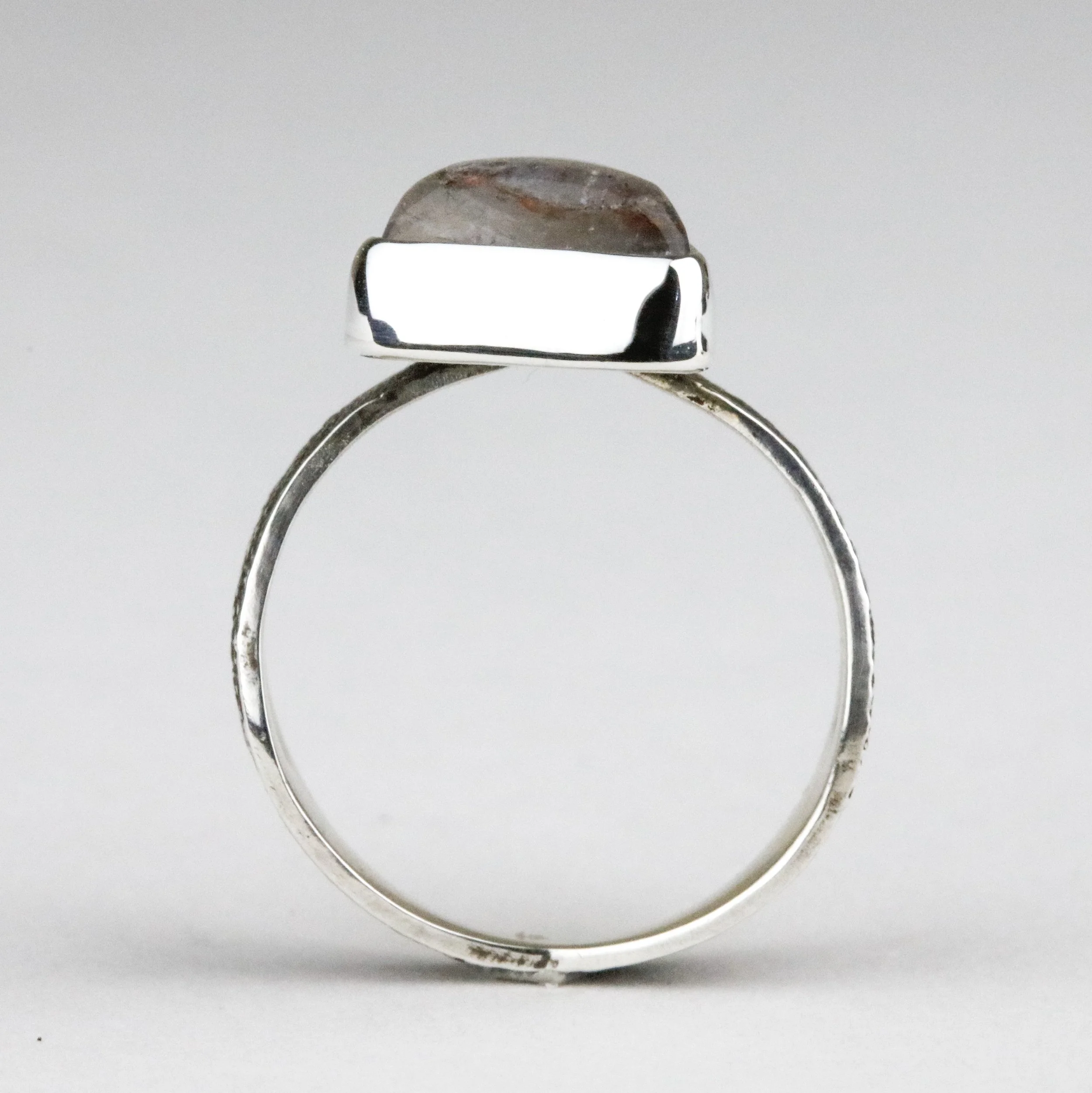An example of a bezel-set stone in a ring where you can see how the strip metal is folded over the stone