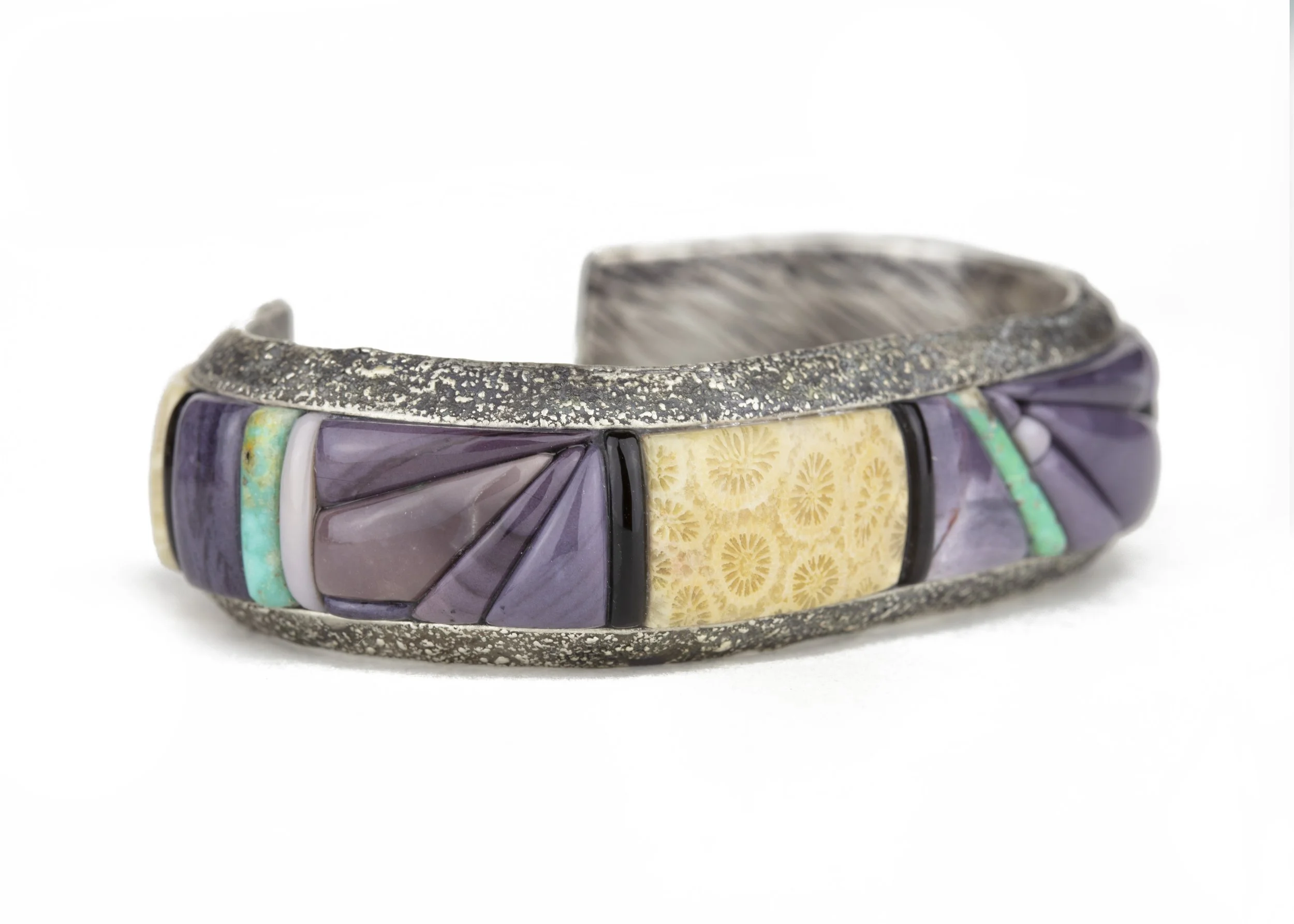 What is cobblestone inlay jewelry? This is a cuff bracelet made using the cobblestone inlay jewelry technique made with hyacinth jasper, agatized coral, turquoise, and obsidian