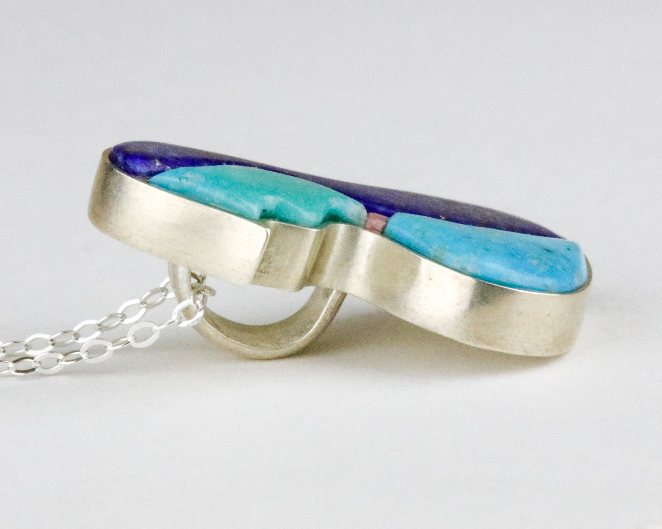 A side view of an inlay pendant to show how it compares to a bezel setting in jewelry