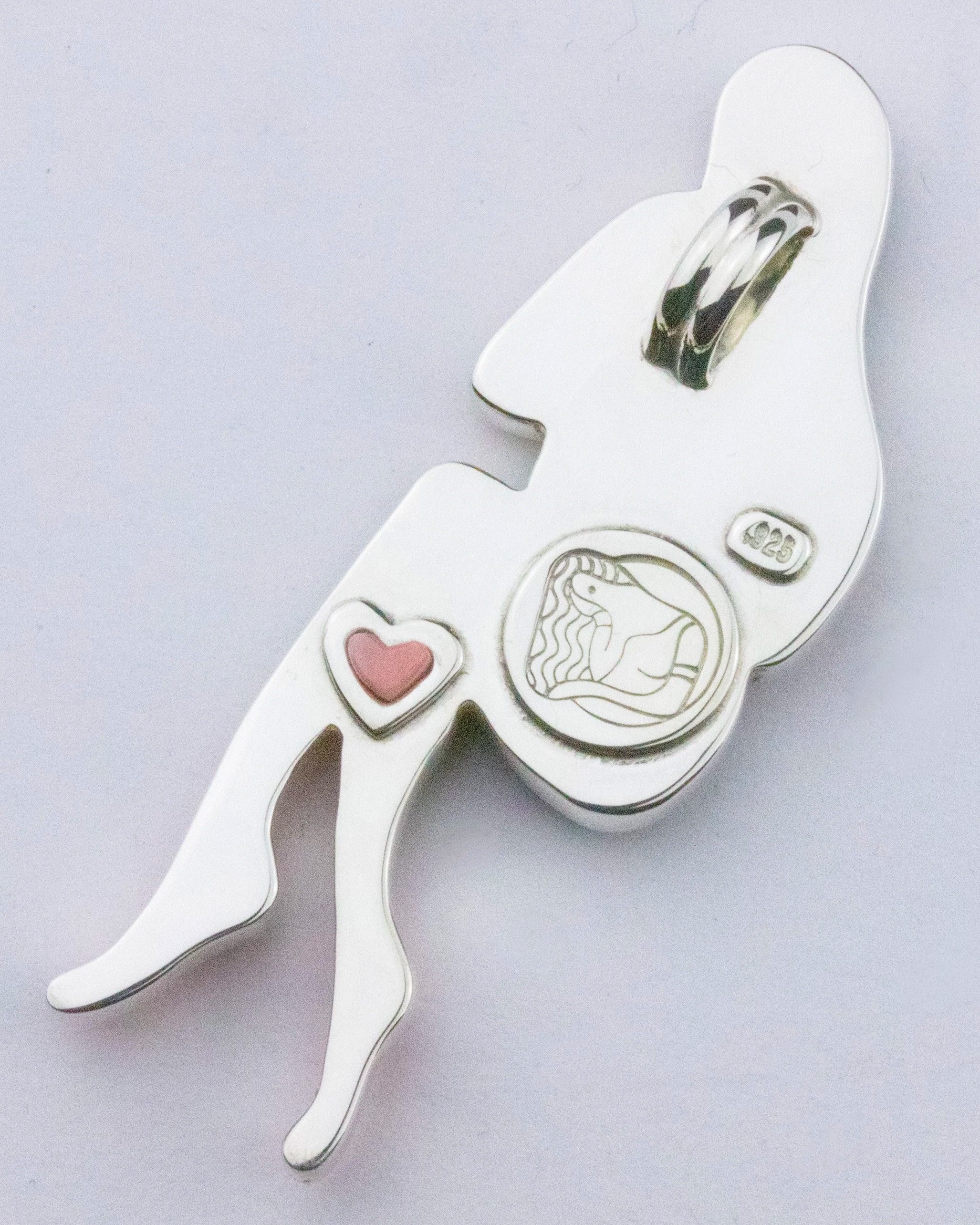 Back view of a figurative inlay pendant, showing the makers mark for Caitlin Albritton Jewelry