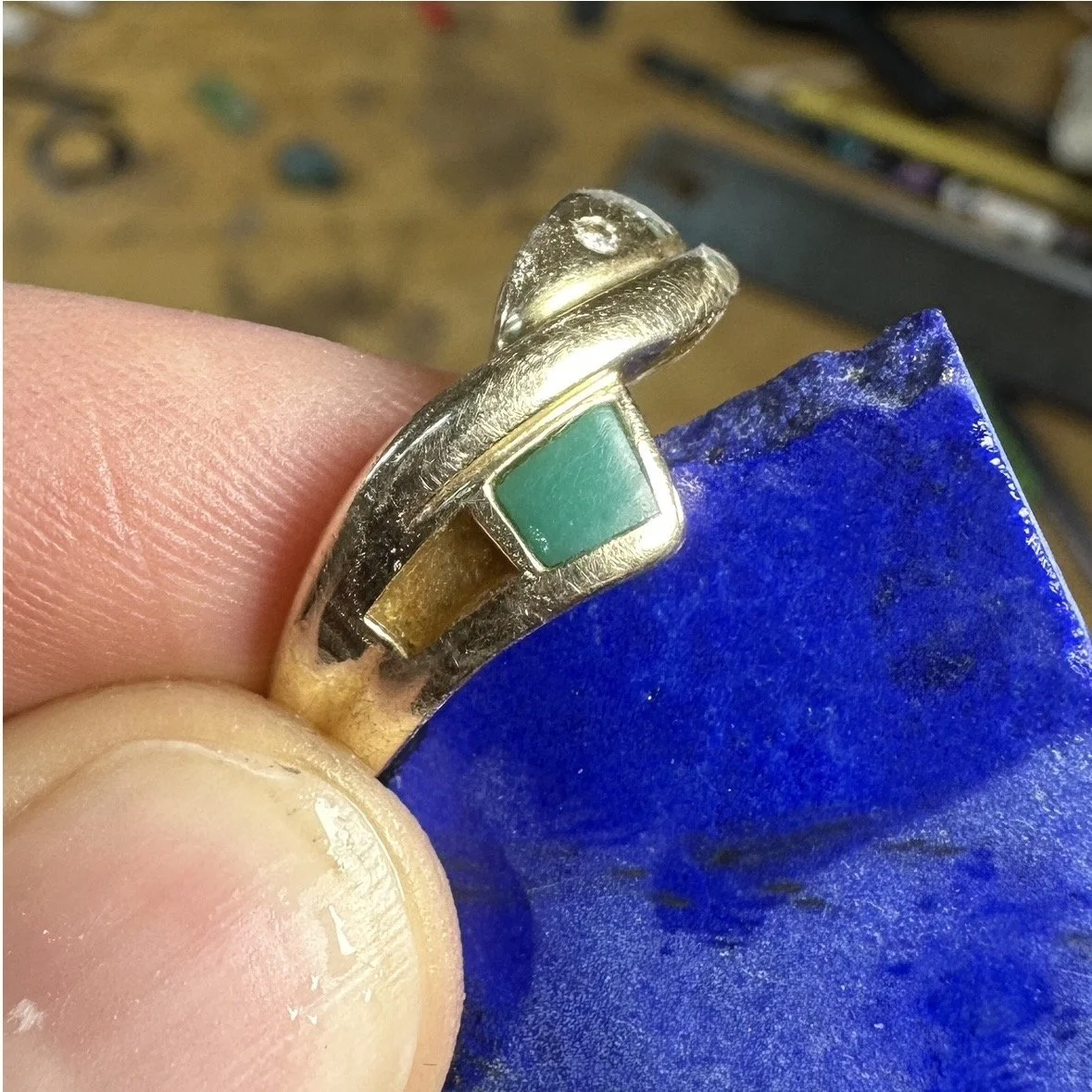 In-process of an inlay wedding ring repair, holding up stone replacement options for my client to pick from