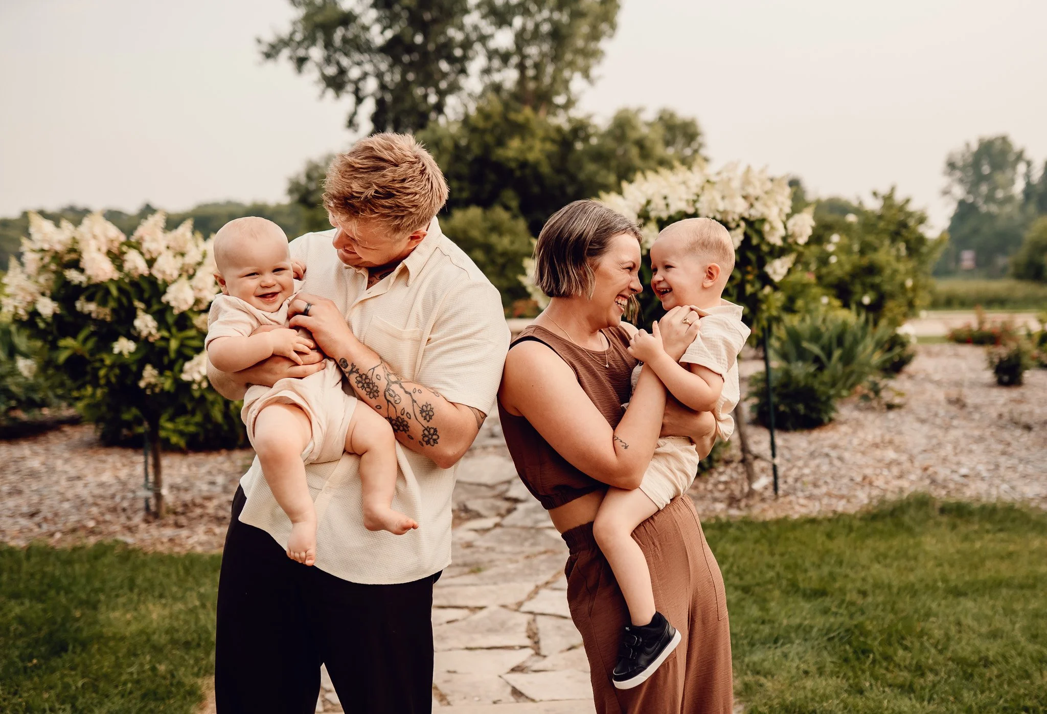 Family with two young kids smiling during an outdoor sunset photo session