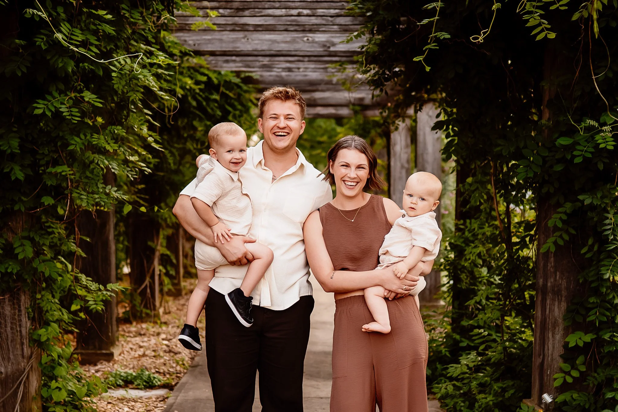 Rochester Minnesota family photographer capturing candid outdoor golden hour session with parents and two children