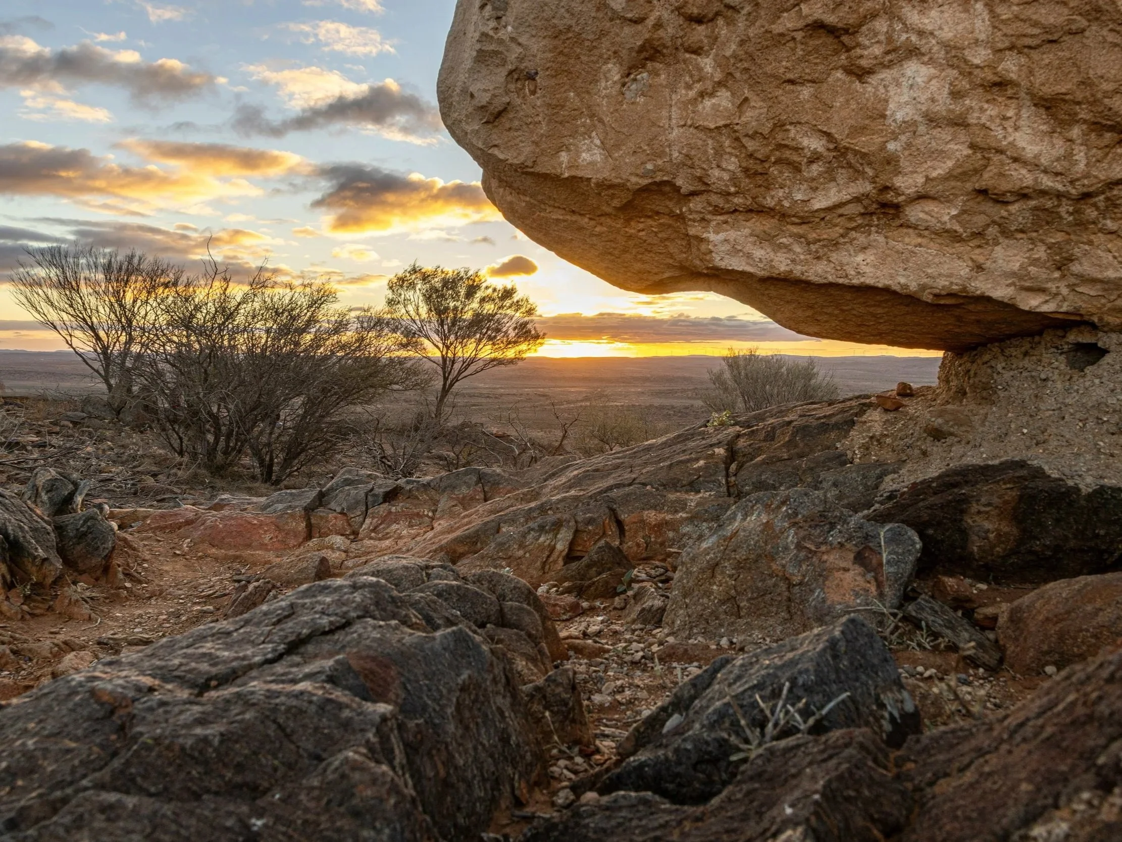 Ancient iron-rich rock formations at sunset in the Pilbara Craton, Western Australia, part of the Archean Hamersley Range.