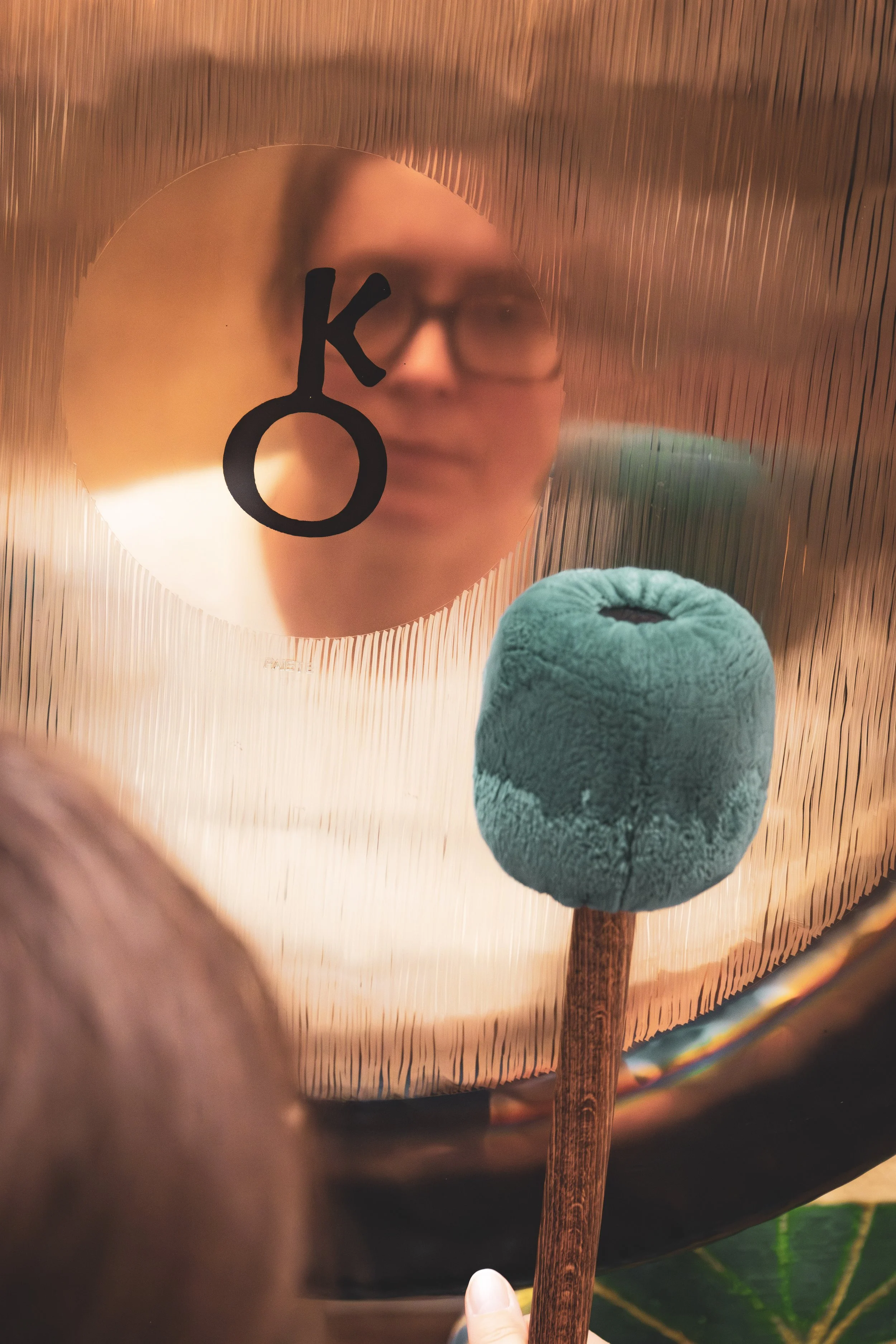 Miroir rond avec symbole chimique du potassium (K) et un bouton en forme de champignon en face.