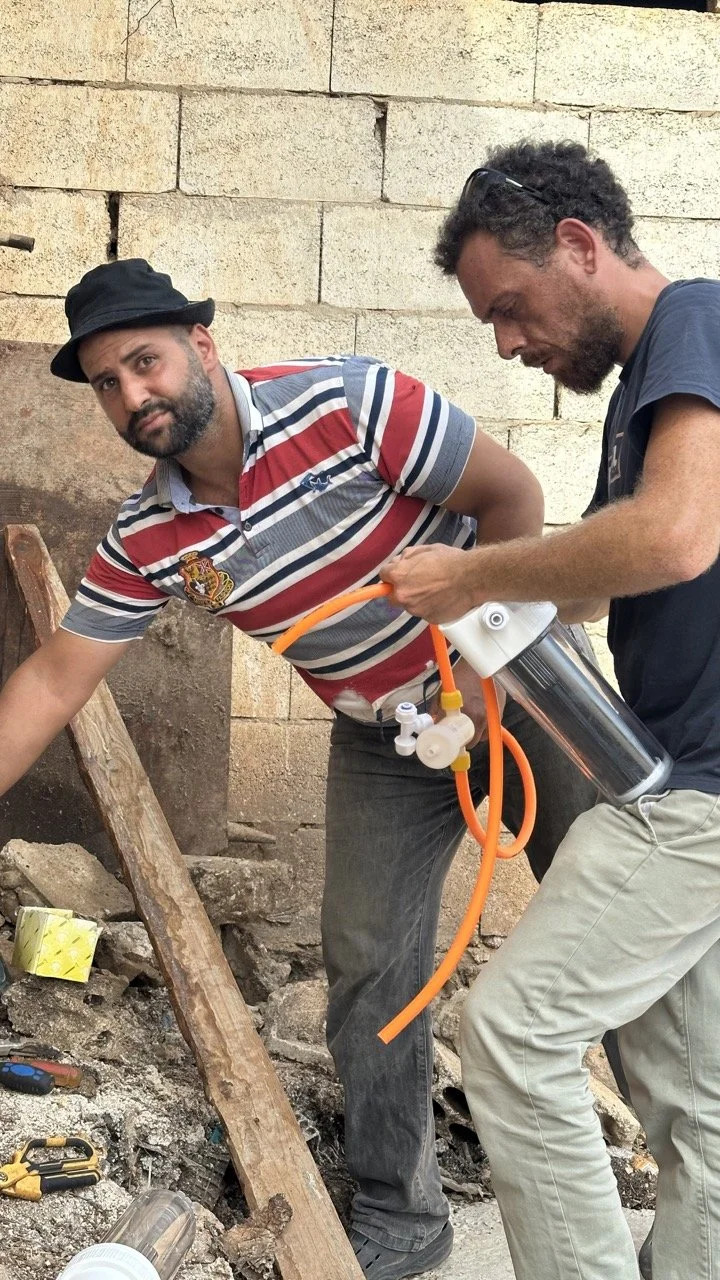 Hand holding dark svermicompost, with more soil in the background.