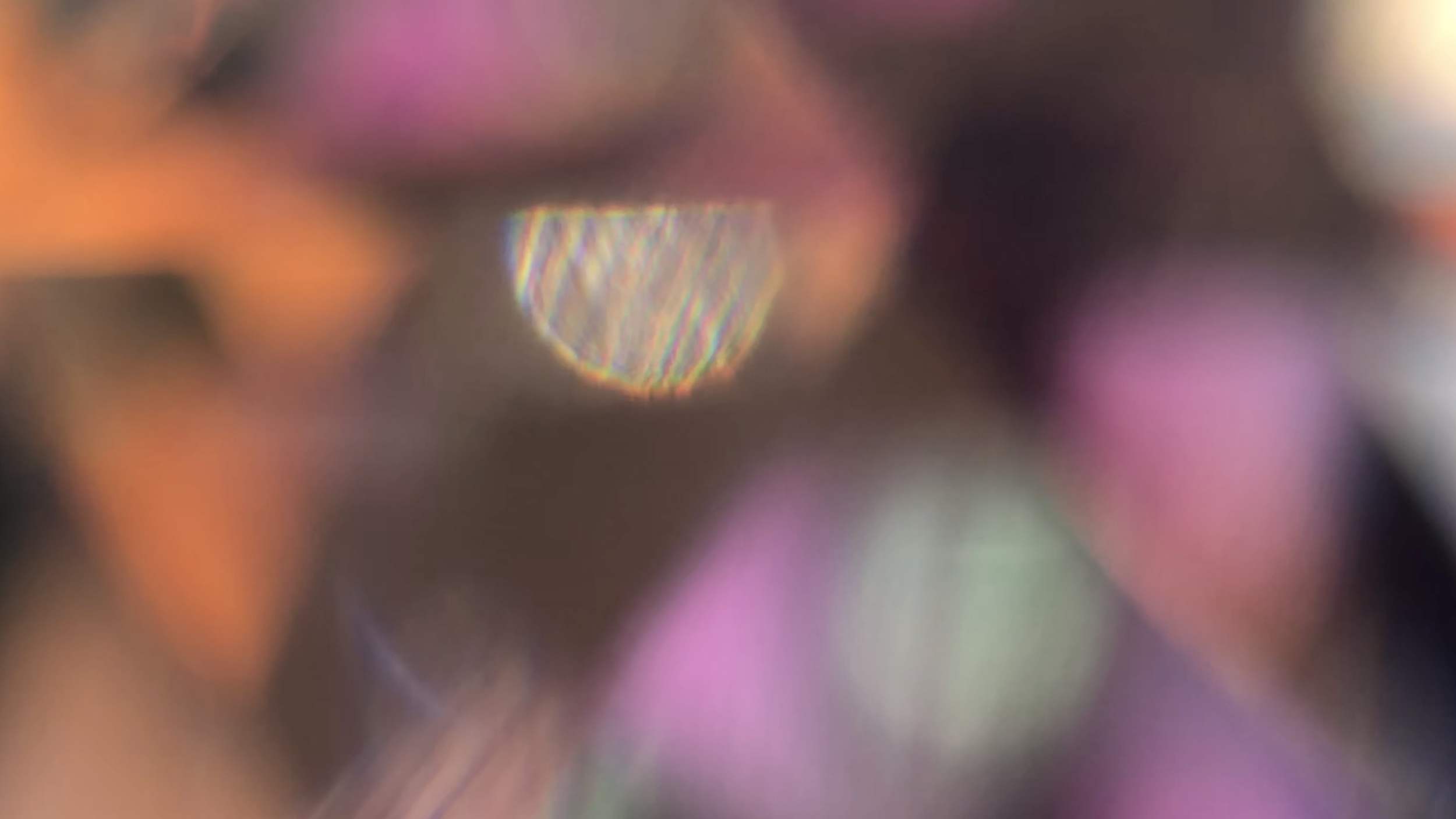 still from the film Towards Light blobs of orange and pink with a sparkle of light