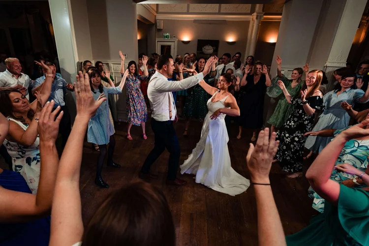 Het bruidspaar danst tussen de juichende gasten
