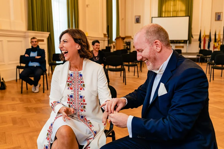Het bruidspaar lacht bij de ringen in het gemeentehuis
