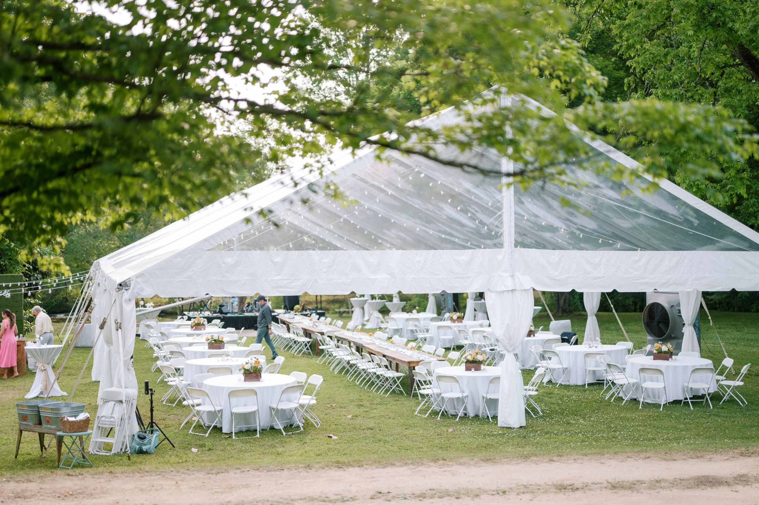 Clear top tent with long reception tables on lawn