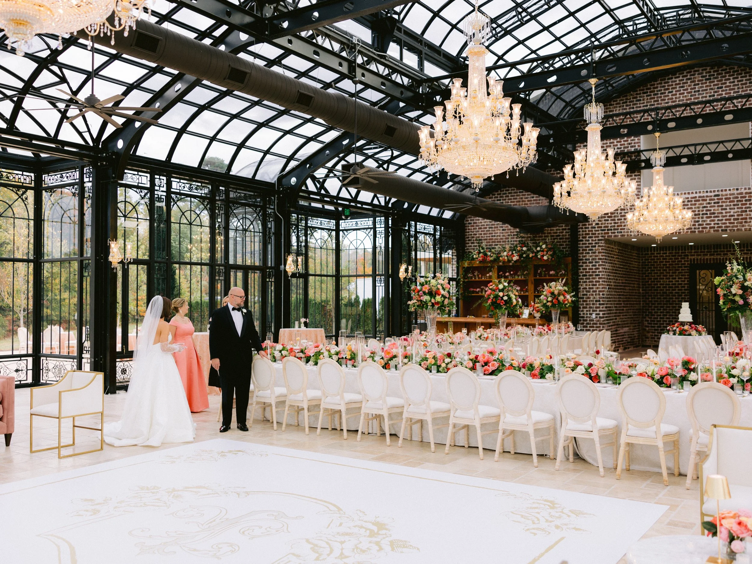 A finished Party Pros reception installation with elegant white seating, chandeliers and event tables