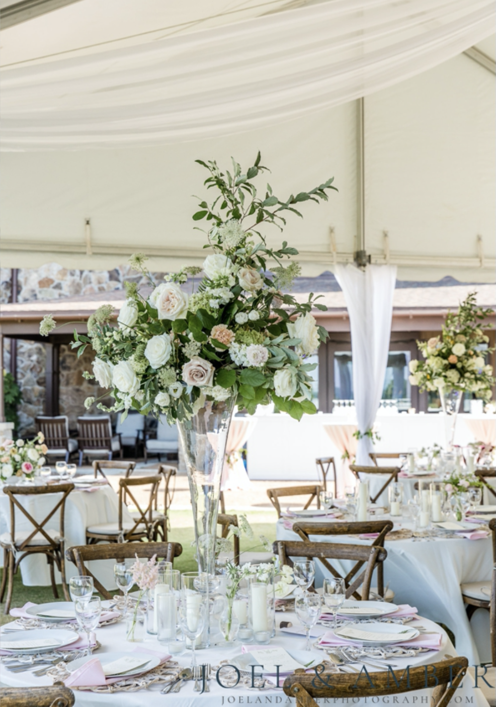 Reception setup beneath a tent with flowers