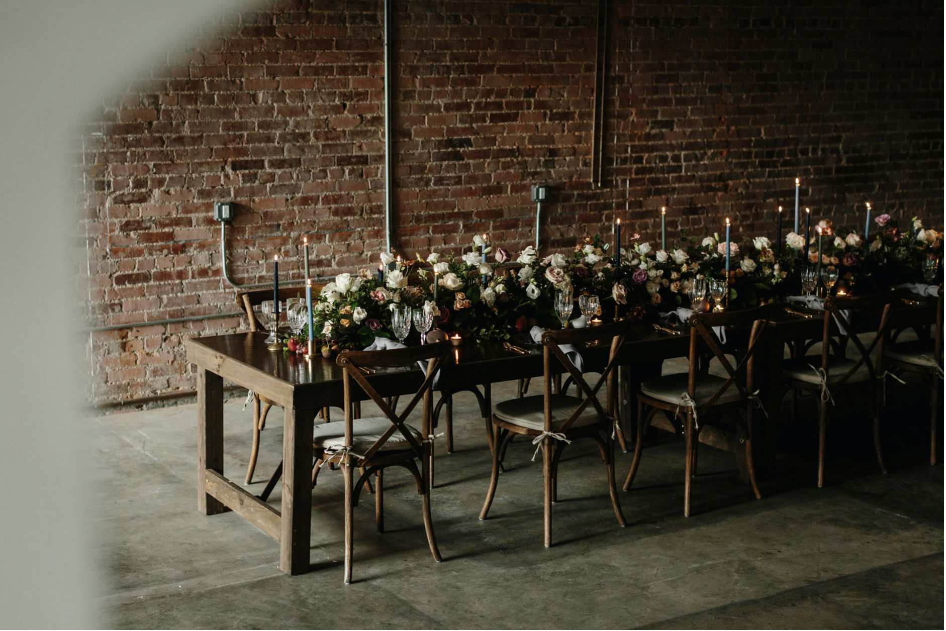 Moody brick wall and styled long dinner table