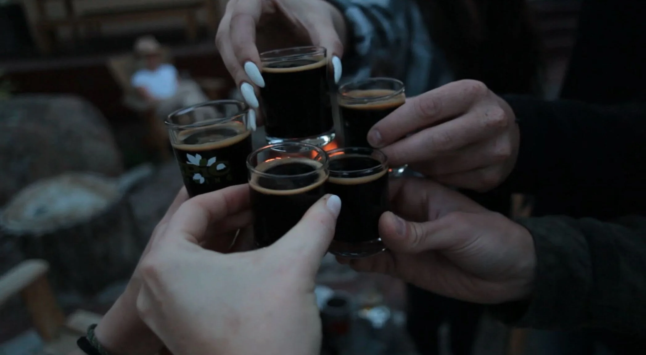 Five friends clink their tasters together.
