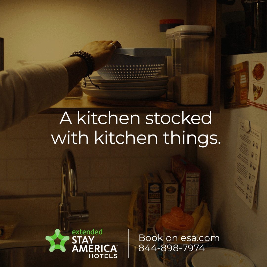 A kitchen shelf with stacked dishes, bowls, and kitchen items, with a hand reaching for a bowl. Overlaid text says, "A kitchen stocked with kitchen things."