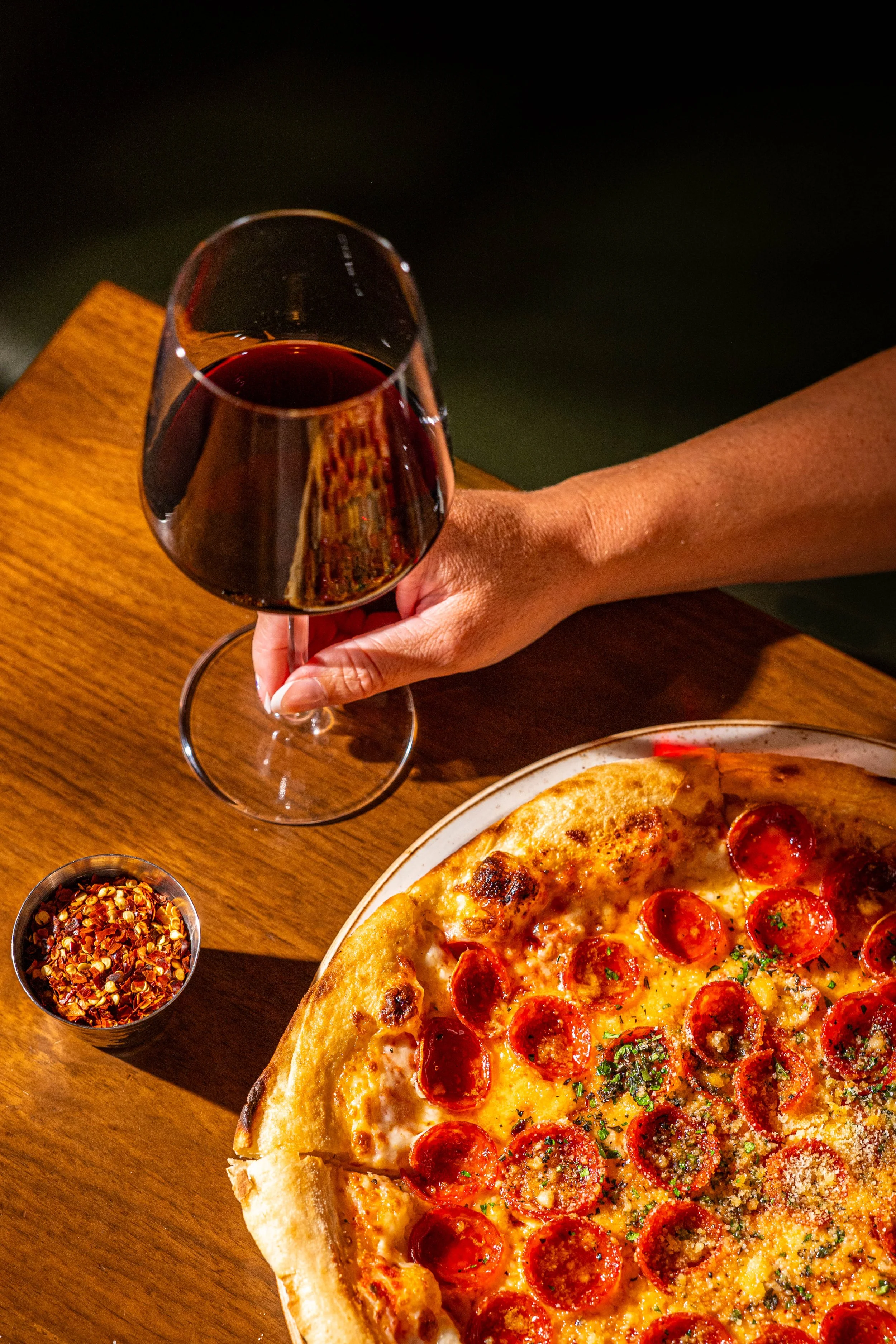 Wine glass and pepperoni pizza