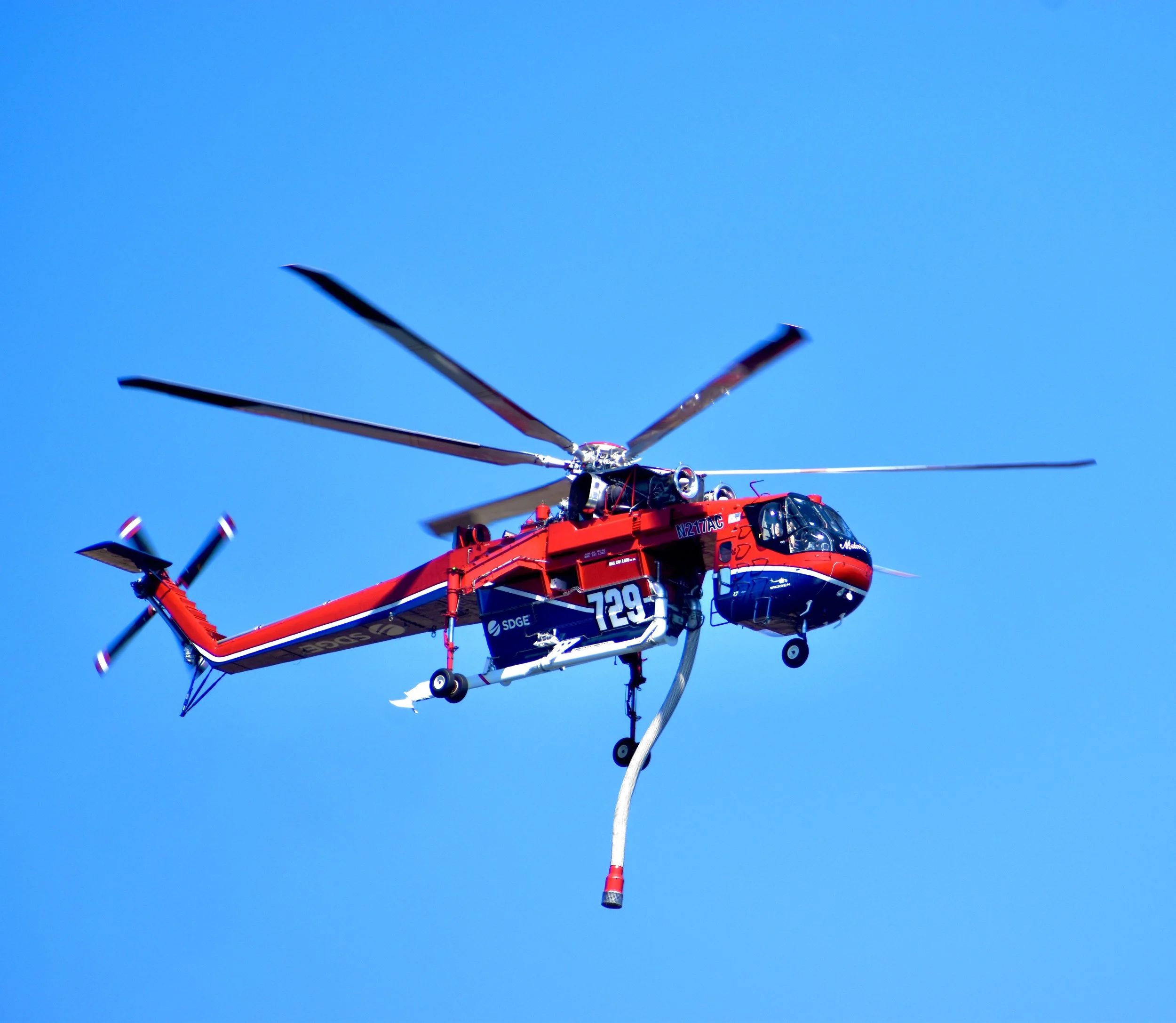 A helicopter flying in a clear blue sky.