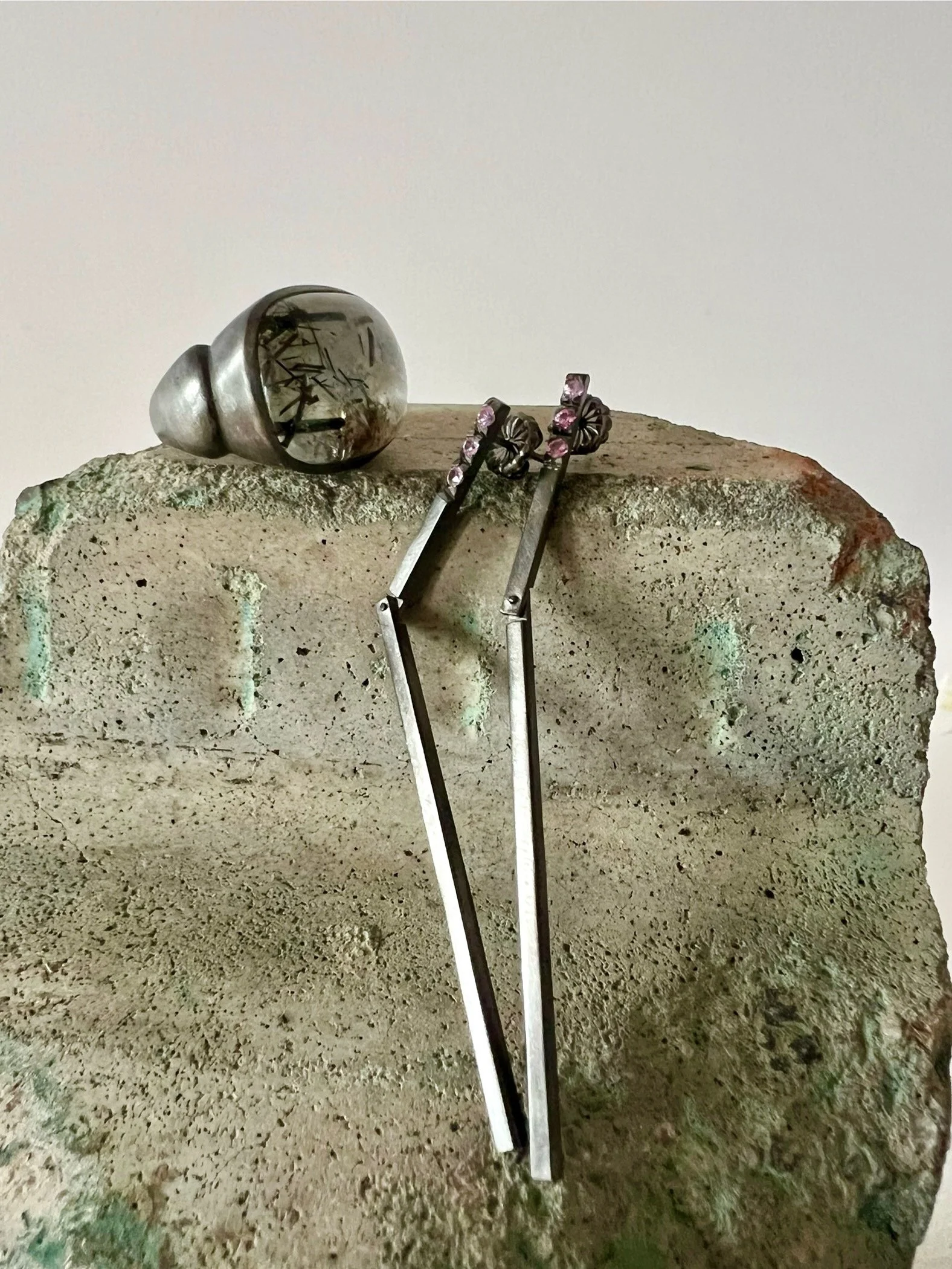 Bomba ring with a rutilated aquamarine  and raya earrings with pink sapphires. Both pieces are rhodium plated