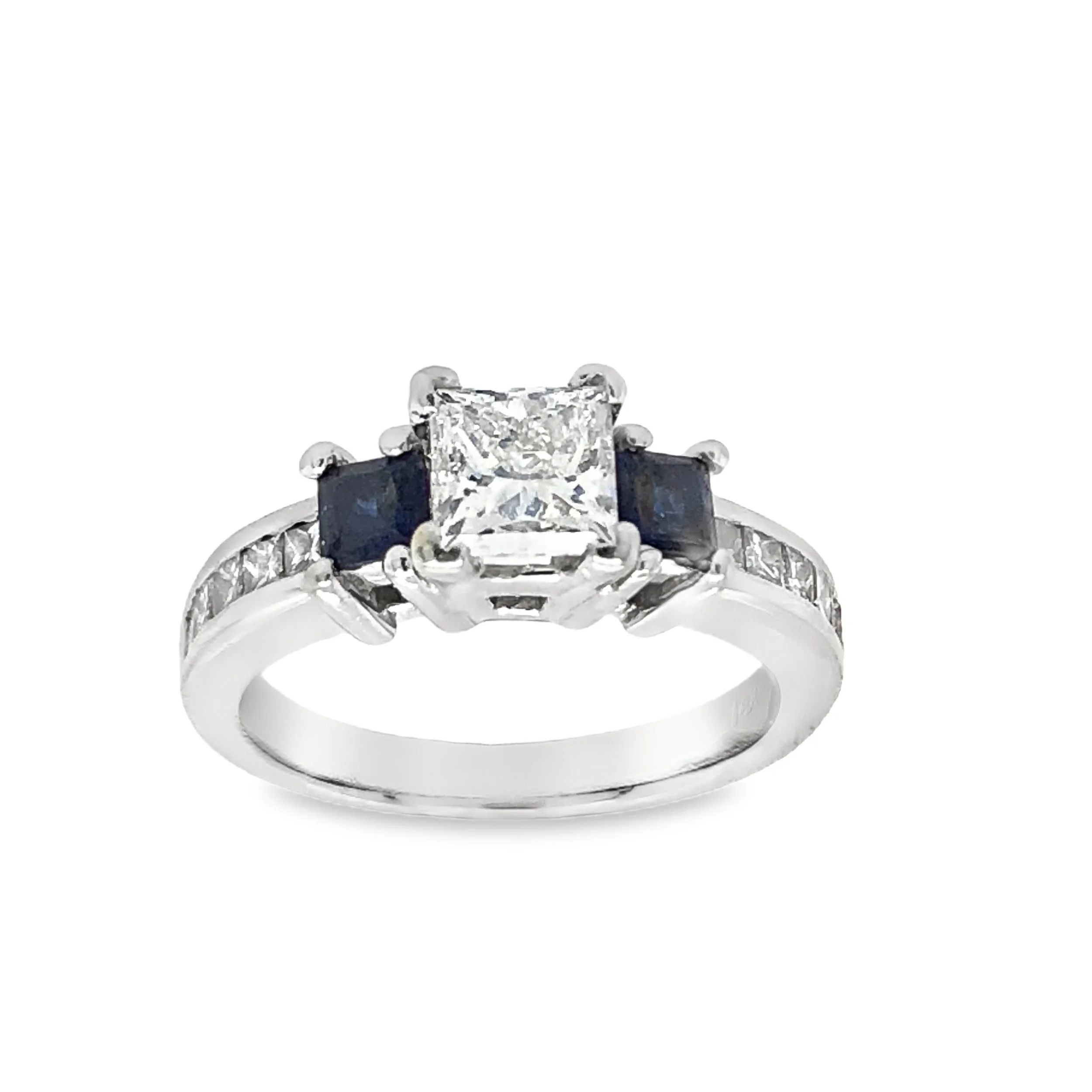 Silver ring with a large princess-cut diamond at the center, flanked by two small dark square stones, and small diamonds embedded along the band.