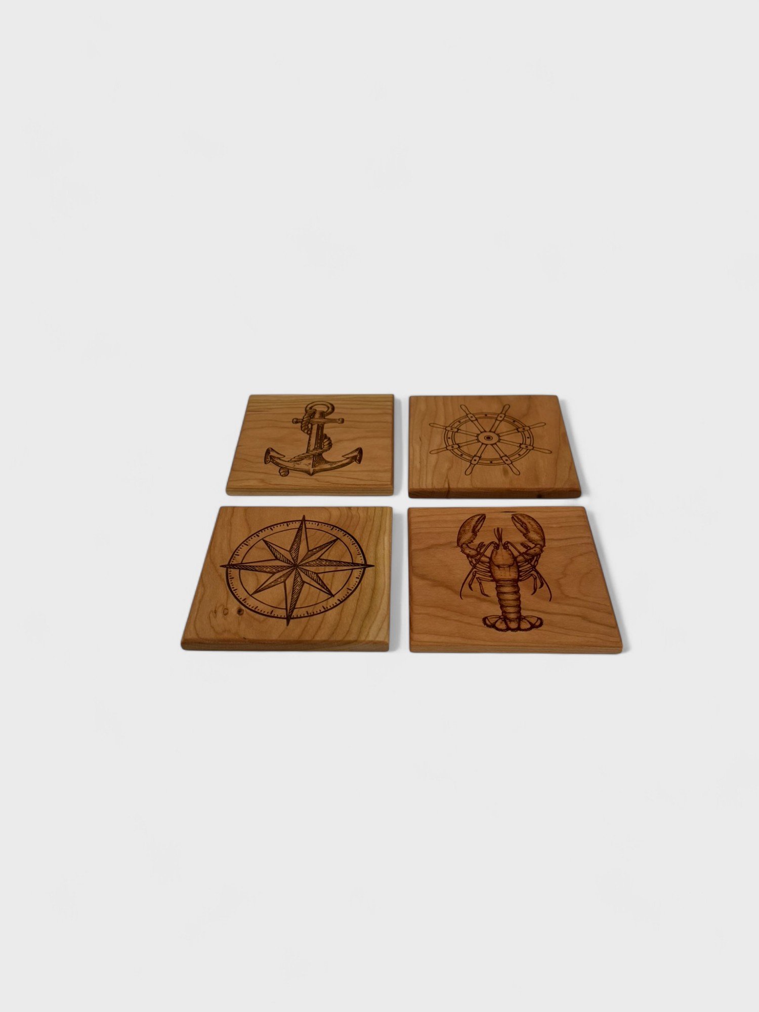 a set of nautical themed wooden coasters made of cherry wood