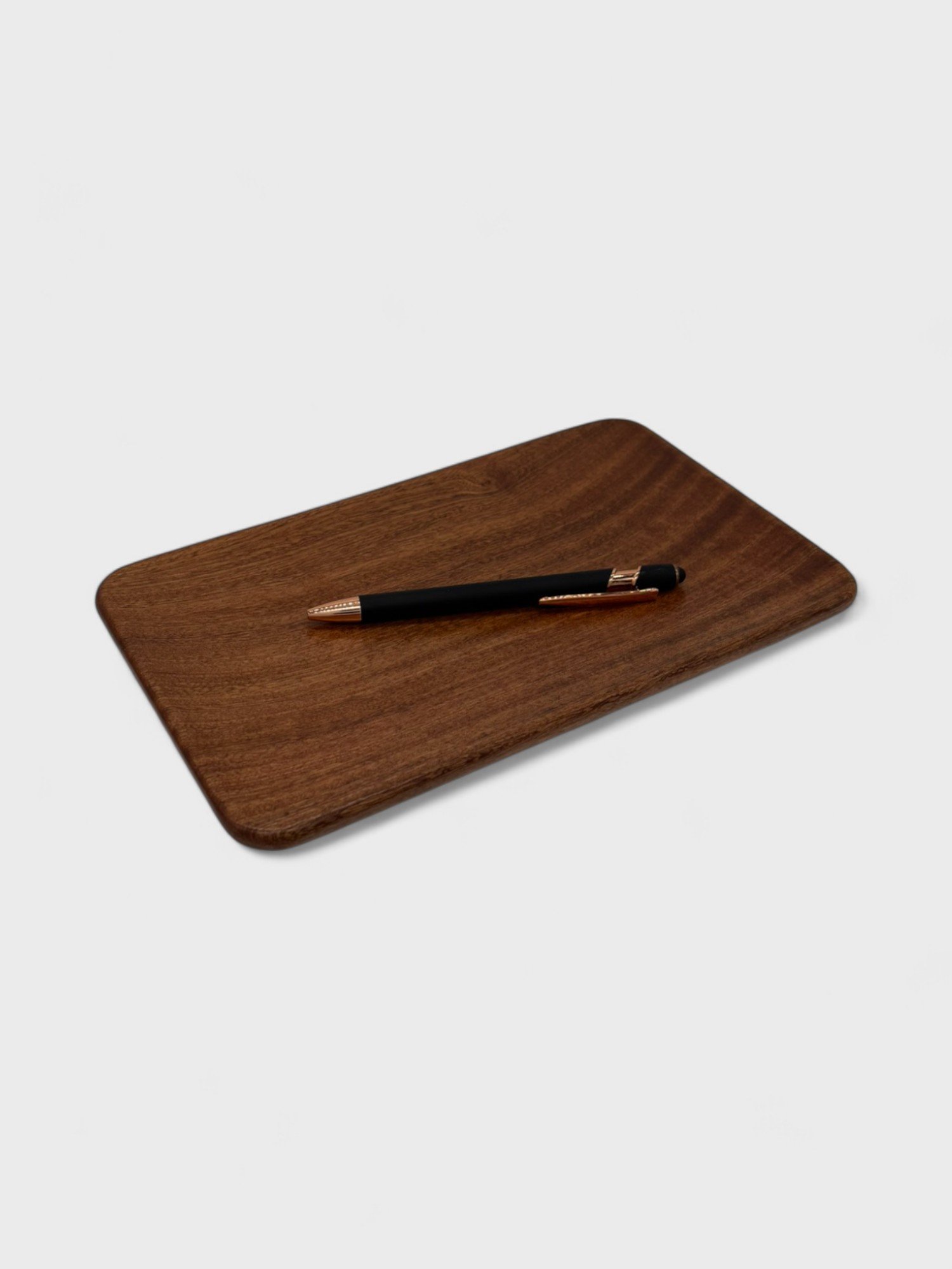 a small tray made from Sepele wood with a pen on it